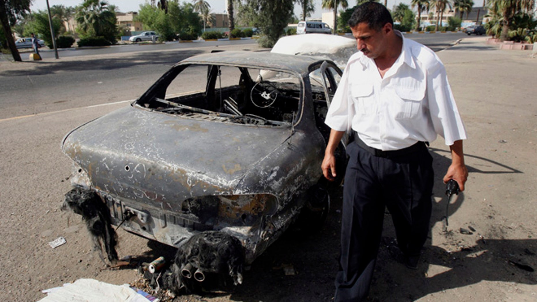 Sept. 25, 2007: An Iraqi traffic policeman inspects a car destroyed by a Blackwater security detail in al-Nisoor Square in Baghdad, Iraq.