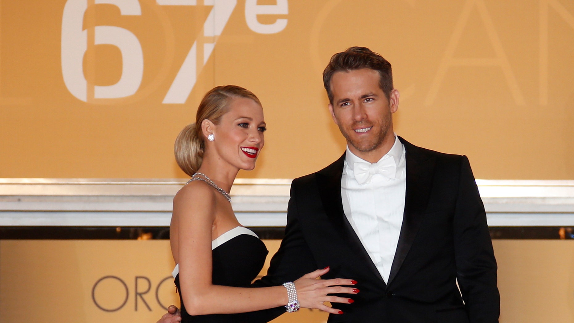 Cast member Ryan Reynolds (R) and his wife actress Blake Lively pose on the red carpet as they arrive for the screening of the film "Captives" (The Captive) in competition at the 67th Cannes Film Festival in Cannes May 16, 2014. REUTERS/Benoit Tessier (FRANCE - Tags: ENTERTAINMENT) - RTR3PJKX