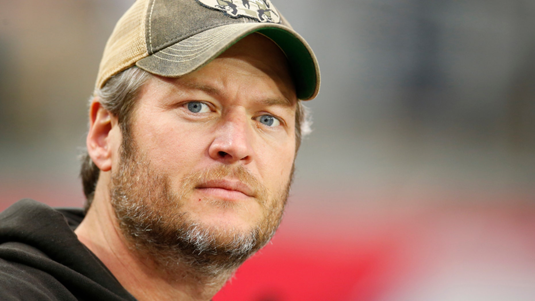 In this Dec. 27, 2015 file photo, singer Blake Shelton watches from the sidelines prior to an NFL football game between the Green Bay Packers and the Arizona Cardinals in Glendale, Ariz.