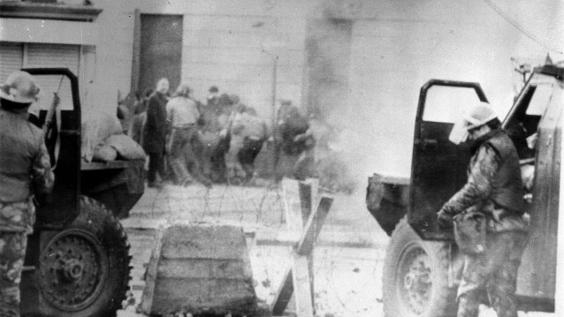 Soldiers take cover behind armored cars on "Bloody Sunday" in 1972.