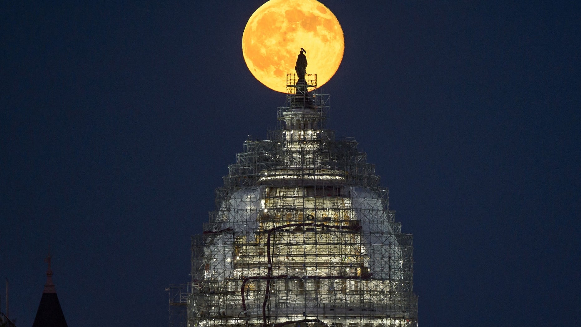 The "blue moon" full moon of July 31, 2015 rises behind the dome the U.S. Capitol in this image from NASA photographer Bill Ingalls.