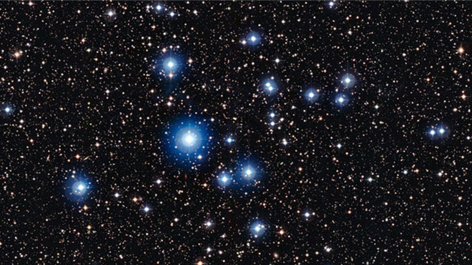 This image from the Wide Field Imager on the MPG/ESO 2.2-metre telescope at ESOs La Silla Observatory in Chile, shows the bright open star cluster NGC 2547. Between the bright stars, far away in the background of the image, many remote galaxies can be seen, some with clearly spiral shapes.