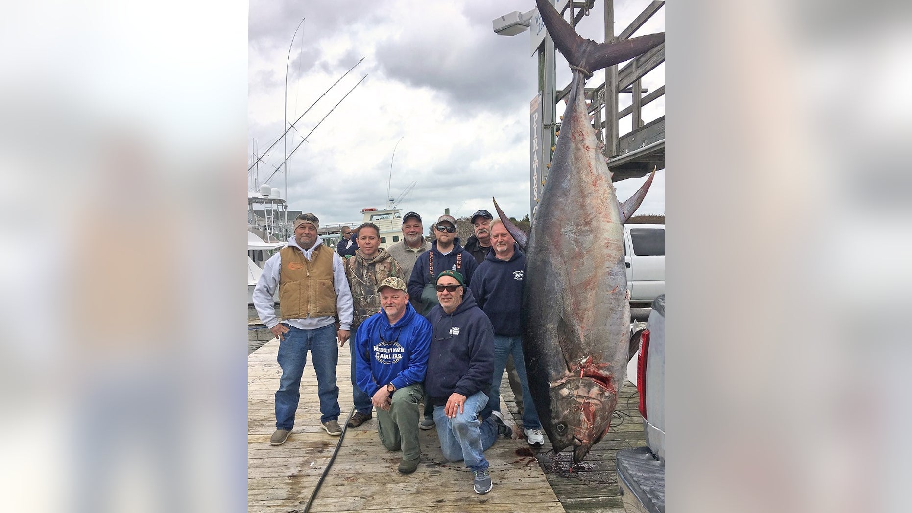 Scott Chambers, (kneeling, left) a retired Army general, caught the bluefin on March 17.
