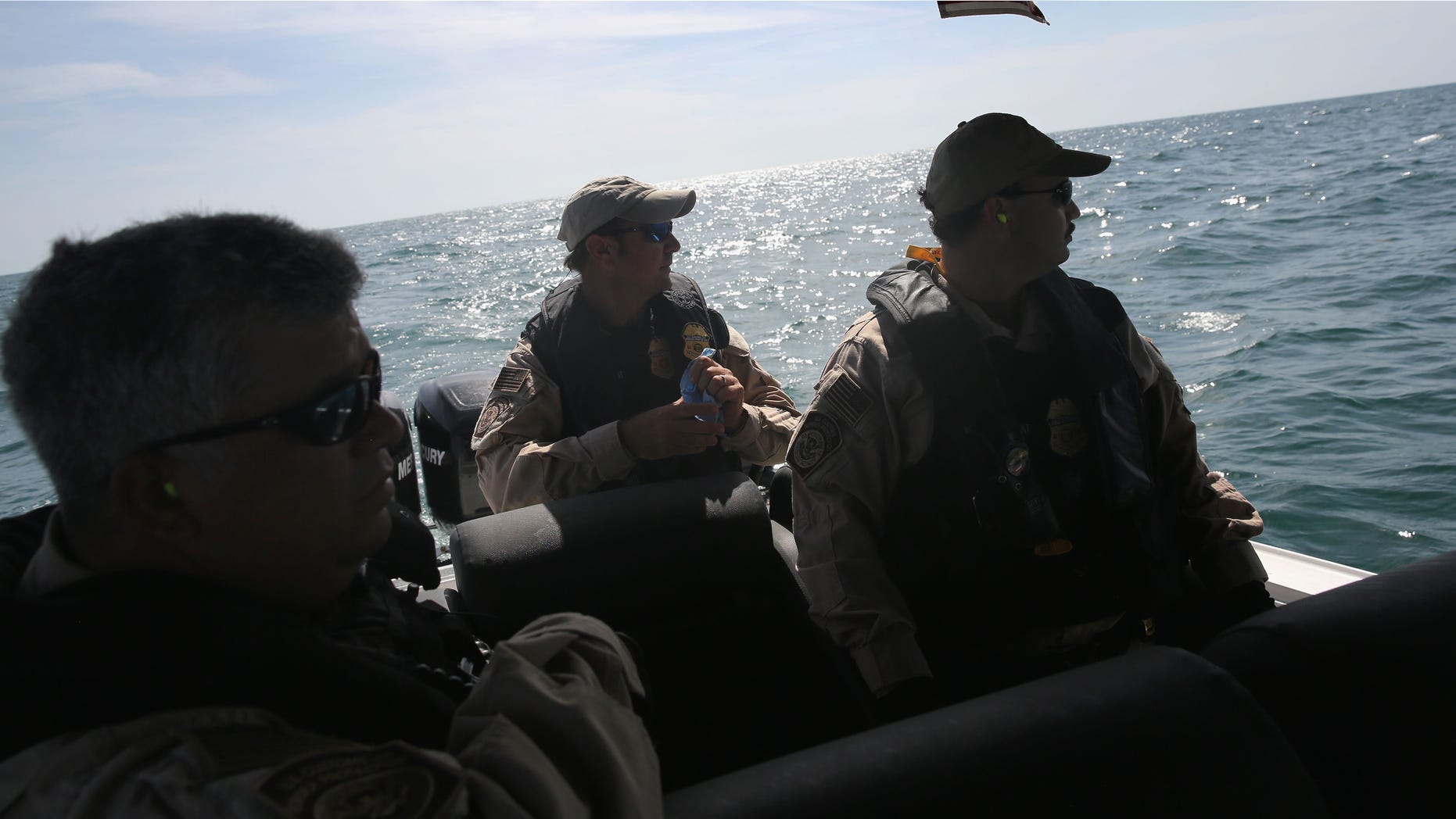 PORT ISABEL, TX - APRIL 12: A boat crew from the U.S. Office of Air and Marine (OAM) looks towards a suspicious boat just across the Mexican border in the Gulf of Mexico on April 12, 2013 near Port Isabel, Texas. The crew patrols coastline waters near the U.S.-Mexico border searching for drug smugglers as well as illegal immigrants, which come across from Mexico near the mouth of the Rio Grande River. The Midnight Express interceptor is a 39 foot 900 horsepower craft capable of chasing smugglers down at 55 knots (63 mph). OAM units also push back illegal fishing boats out of U.S. waters. (Photo by John Moore/Getty Images)