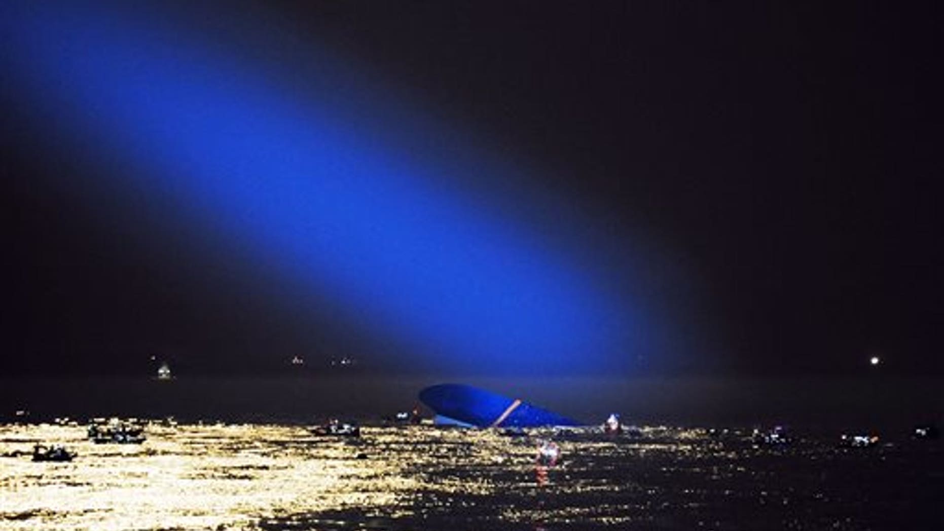 Blue search light cast by South Korean Coast Guard helicopter shows a sunken ferry in the water off the southern coast near Jindo, South Korea, Thursday, April 17, 2014. Fears rose Thursday for the fate of more than 280 passengers still missing more than 24 hours after their ferry flipped onto its side and filled with water off the southern coast of South Korea. (AP Photo/Yonhap) KOREA OUT