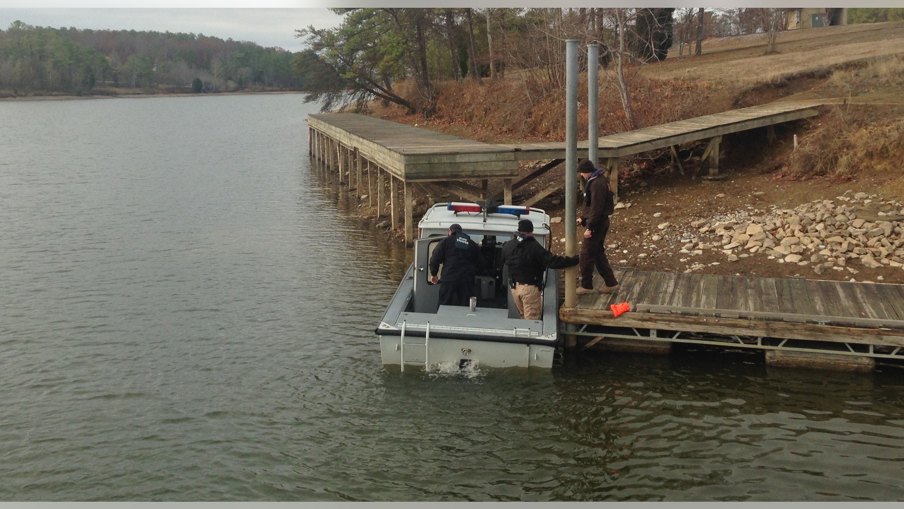 Alabama State Troopers arrive, Wednesday, Dec. 14, 2016, to search for a missing victim after a vehicle drove off a boat landing Tuesday in northeastern Alabama at Leesburg Landing in Cherokee County, Ala. An official says four people are dead and that crews are searching for a fifth person. (William Thornton/AL.com via AP)