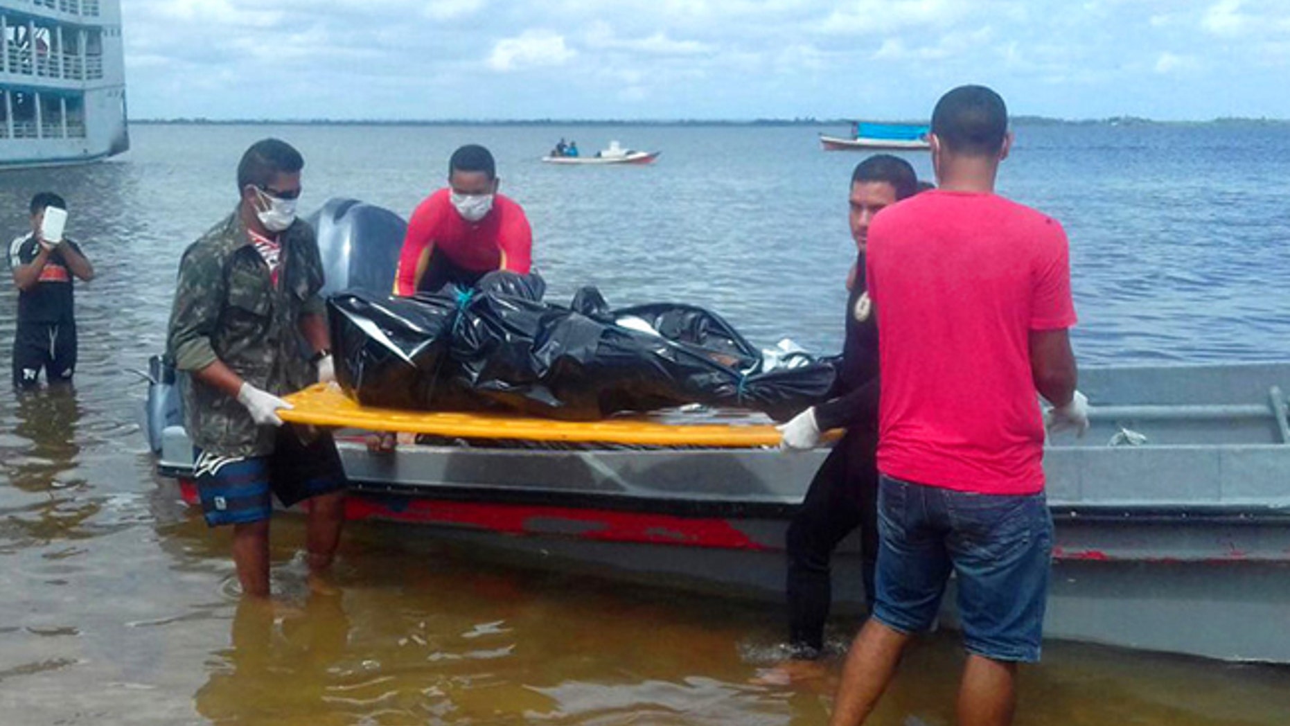 Rescue workers carry a body recovered from the Xingu River in this image released by Brazil's Secretary of Social Communication.