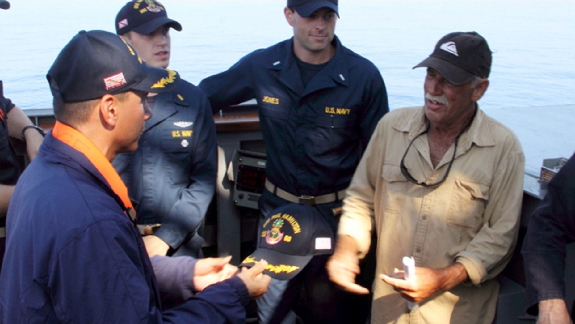 In this photo provided by the U.S. Navy, Cmdr. John Barsano, welcomes Ron Ingraham aboard the Arleigh Burke-class guided-missile destroyer USS Paul Hamilton after rescuing him near Hawaii.