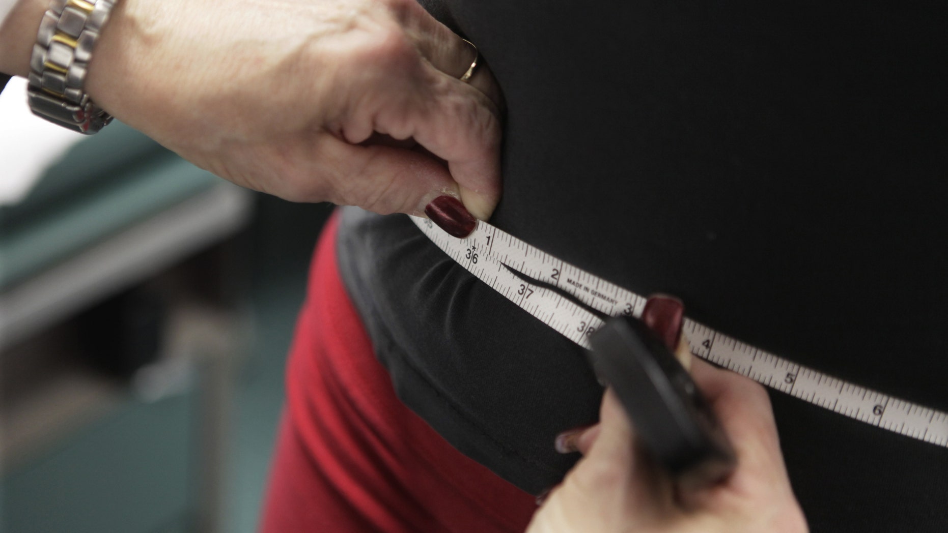 FILE - In this Jan. 20, 2010, file photo, a waist is measured during an obesity prevention study at Rush University Medical Center in Chicago. The bathroom scale may show a good number but how much of that weight is fat, not muscle? New studies are adding to the evidence that the scale doesn't always tell the whole story when it comes to weight-related health risks. (AP Photo/M. Spencer Green, File)