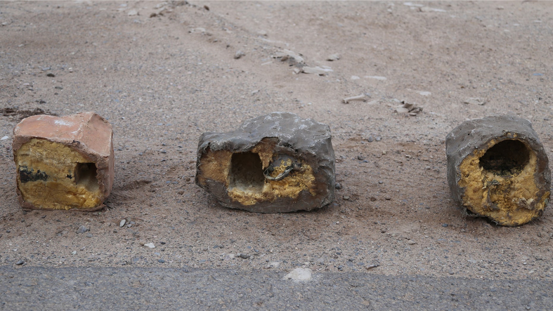 In this undated photograph provided by Conflict Armament Research, an independent London-based group that researches battlefield weaponry, three explosives disguised as rocks are on display in Yemen.