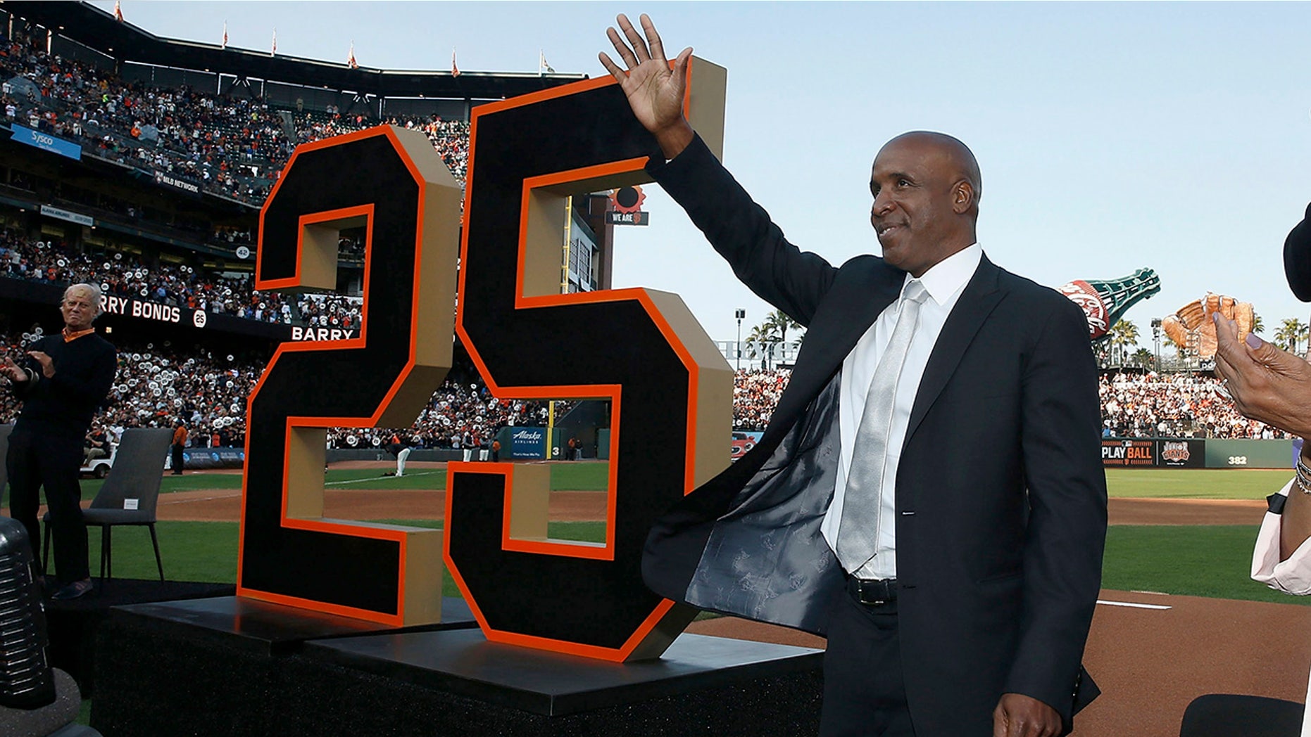 Former San Francisco Giants player Barry Bonds waves during a ceremony to retire his jersey number before a baseball game between the Giants and the Pittsburgh Pirates in San Francisco, Aug. 11, 2018.