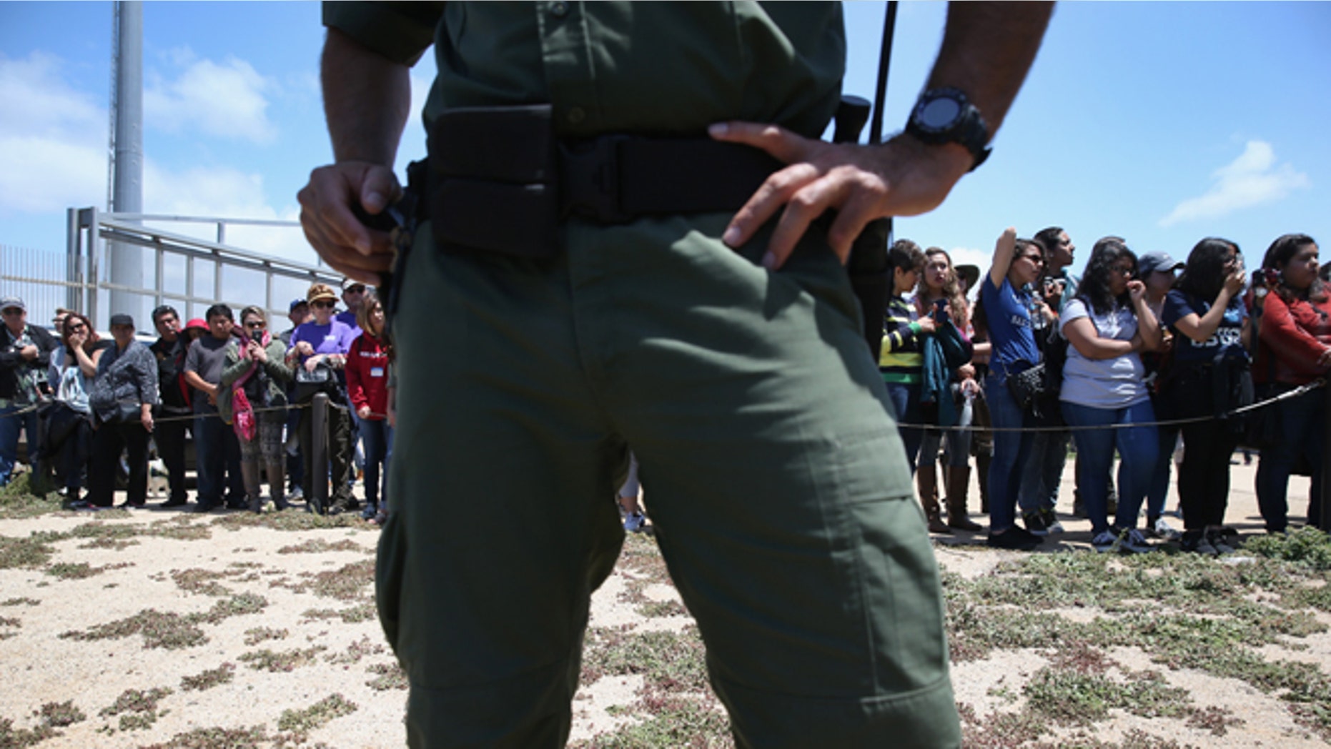 SAN DIEGO, CA - APRIL 30: A U.S. Border Patrol agent stands guard as families prepare to meet loved ones at the U.S.-Mexico Border fence during a "Opening the Door of Hope" event on April 30, 2016 in San Diego, California. Five families, with some members living in Mexico and others in the United States, were permitted to meet and embrace for three minutes each at a door in the fence, which the U.S. Border Patrol opened to celebrate Mexican Children's Day. It was only the third time the fence, which separates San Diego from Tijuana, had been opened for families to briefly reunite. The event was planned by the immigrant advocacy group Border Angels. (Photo by John Moore/Getty Images)