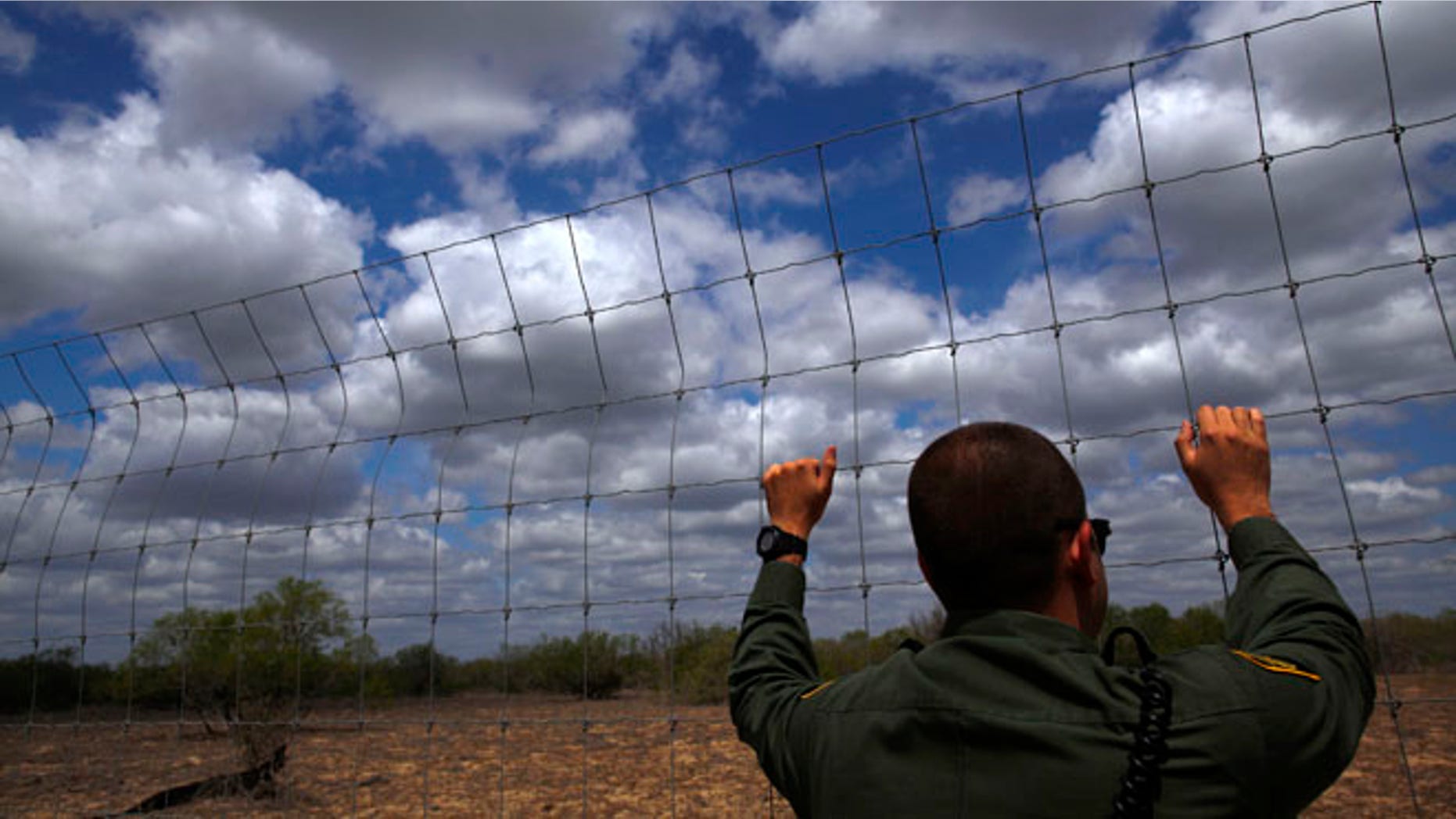 March 29, 2013: An immigration agent looks out at the desert near Falfurrias, Texas.