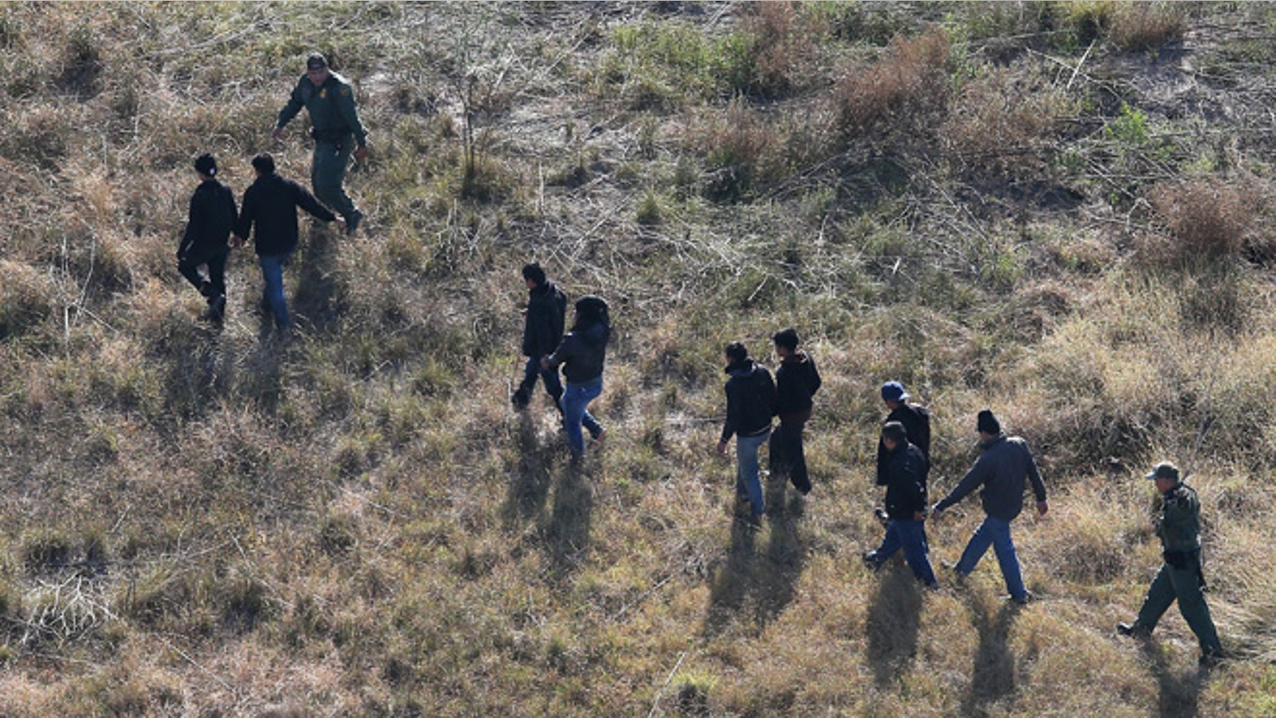 LA GRULLA, TX - DECEMBER 10: U.S. Border Patrol agents lead undocumented immigrants out the brush after capturing them near the U.S.-Mexico border on December 10, 2015 at La Grulla, Texas. Border security remains a key issue in the U.S. Presidential campaign. (Photo by John Moore/Getty Images)
