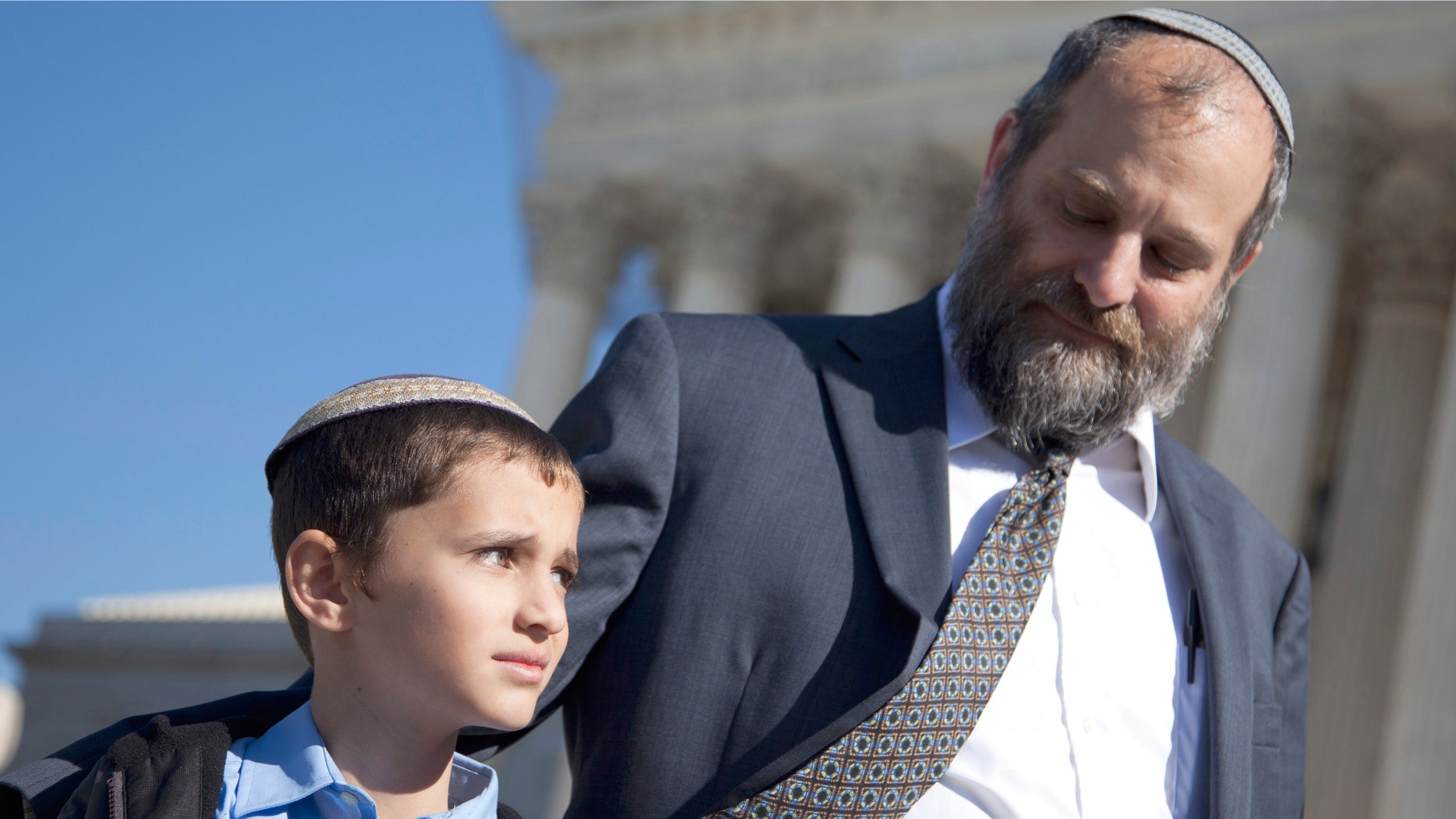 Nov. 7, 2011: Ari Zivotofsky, right, stands with his nine-year-old son, Menachem, outside the Supreme Court in Washington.