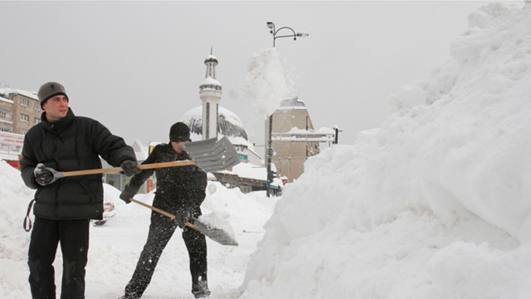 Feb. 4, 2012: Bosnian men shovel deep snow to clear the path for pedestrians, in the Bosnian capital of Sarajevo.
