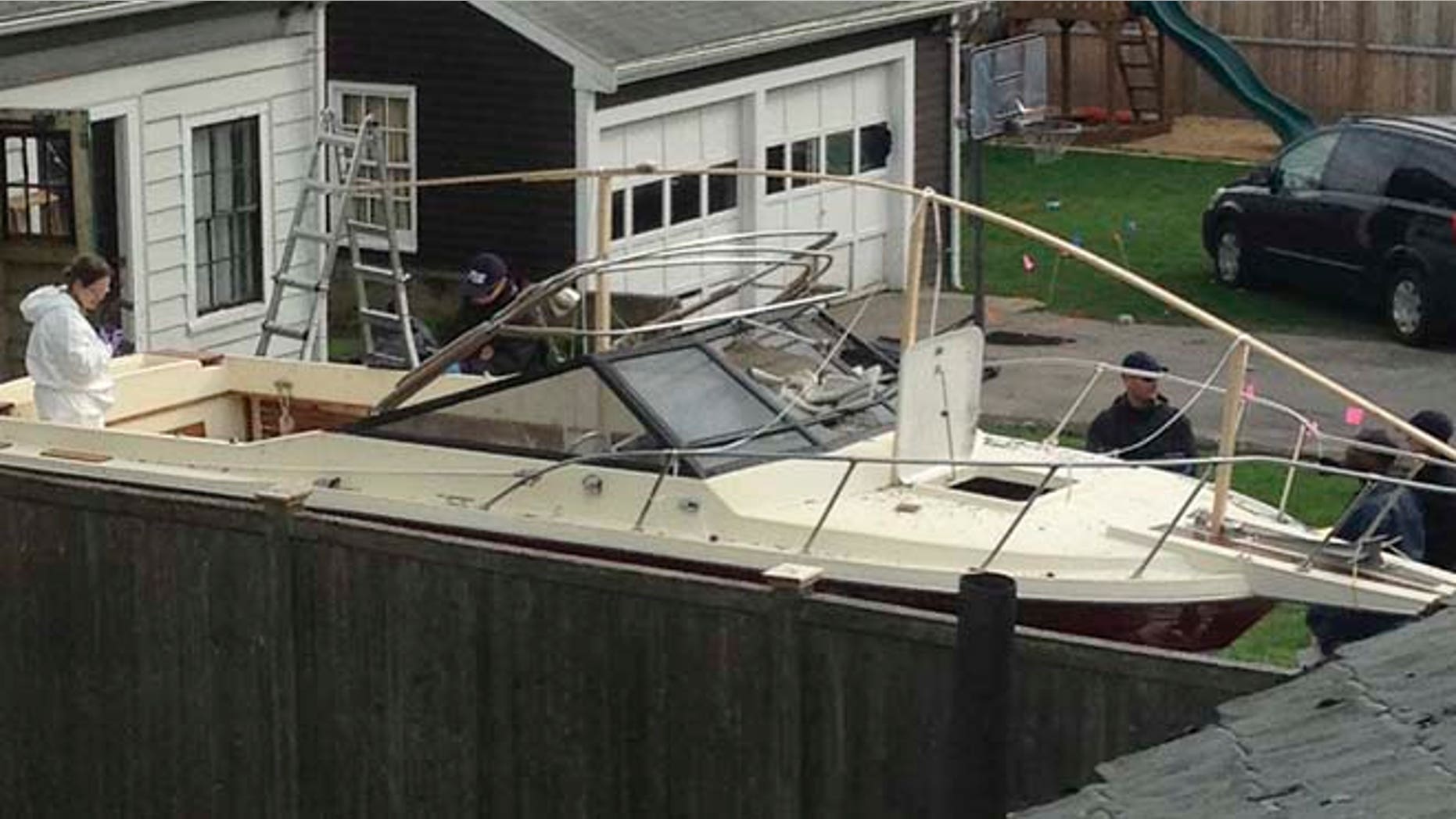 In this April 20, 2013 file photo, investigators work near the boat in Watertown, Mass., where the previous night police captured Dzhokhar Tsarnaev, the surviving Boston Marathon bombing suspect, after a car chase and gun battle earlier in the day left his older brother dead.