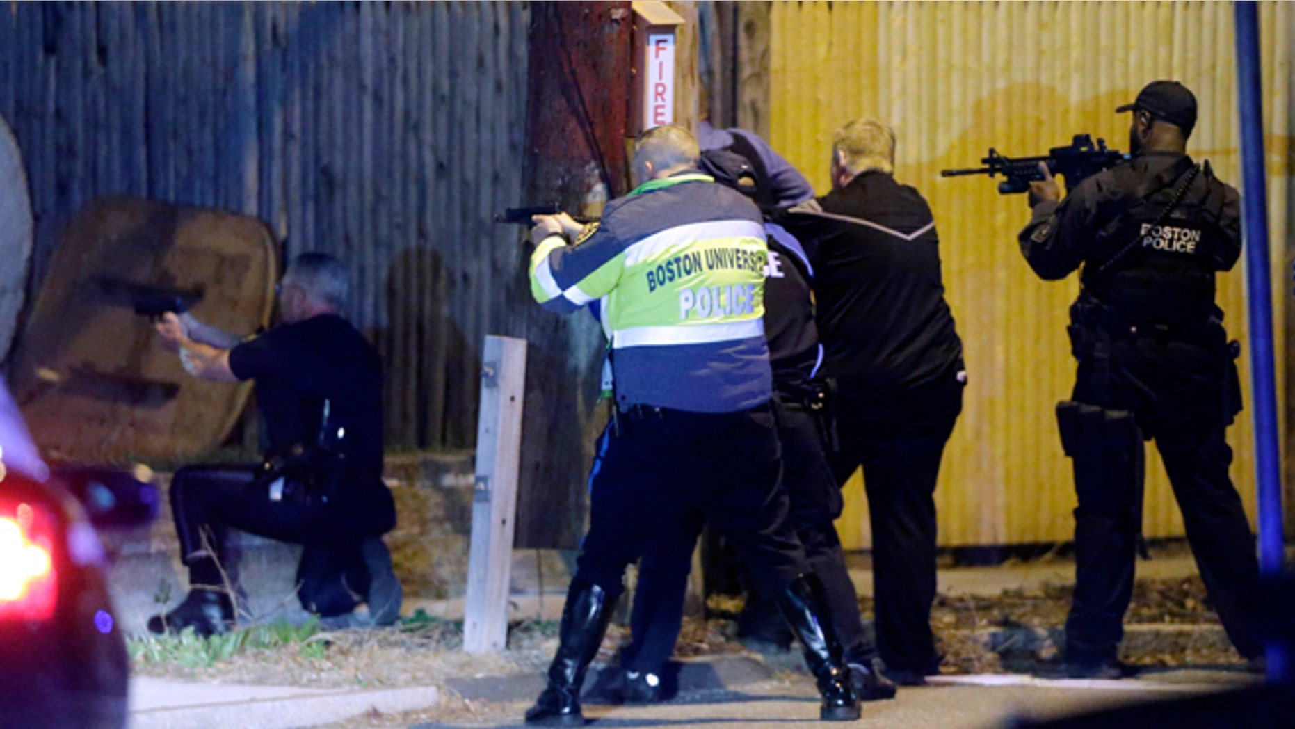 April 19, 2013. Police officers aim their weapons in a Watertown, Mass., neighborhood during a hunt for the Boston Marathon bombing suspects.