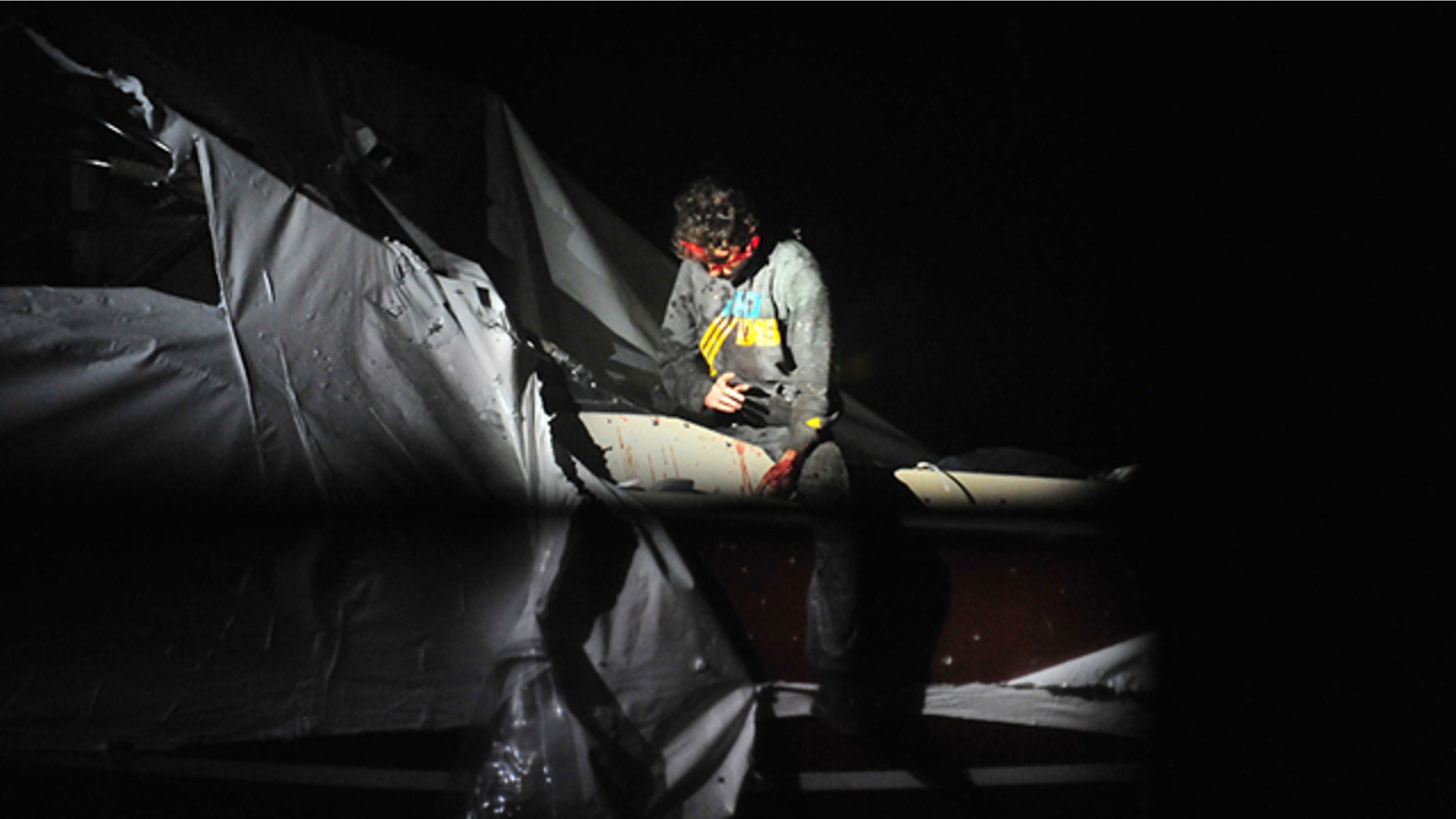 April 19, 2013: In this photo provided by the Massachusetts State Police, Boston Marathon bombing suspect Dzhokhar Tsarnaev leans over in a boat at the time of his capture by law enforcement authorities in Watertown, Mass.