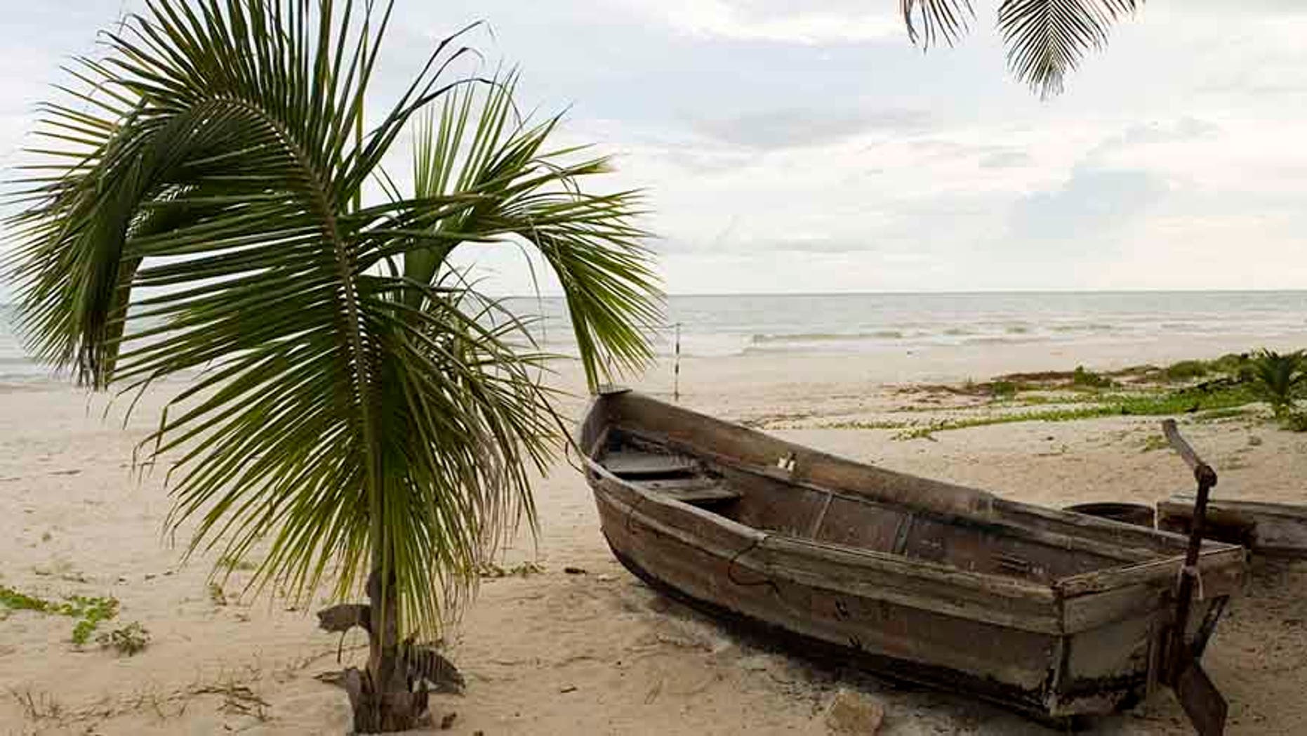A boat, which members of the Mexican Navy and local villagers say was abandoned by people smugglers transporting Cubans to the Yucatan peninsula, lies on a beach in the community of Cuyo on the Yucatan peninsula October 10, 2007. Record numbers of Cubans are now using Mexico as their route to the U.S. instead of the Straits of Florida. Cubans, unlike other Latino migrants, just have to request political asylum to be allowed to enter the U.S. legally. Picture taken October 10, 2007. REUTERS/Victor Ruiz (MEXICO) - RTR1UTGY
