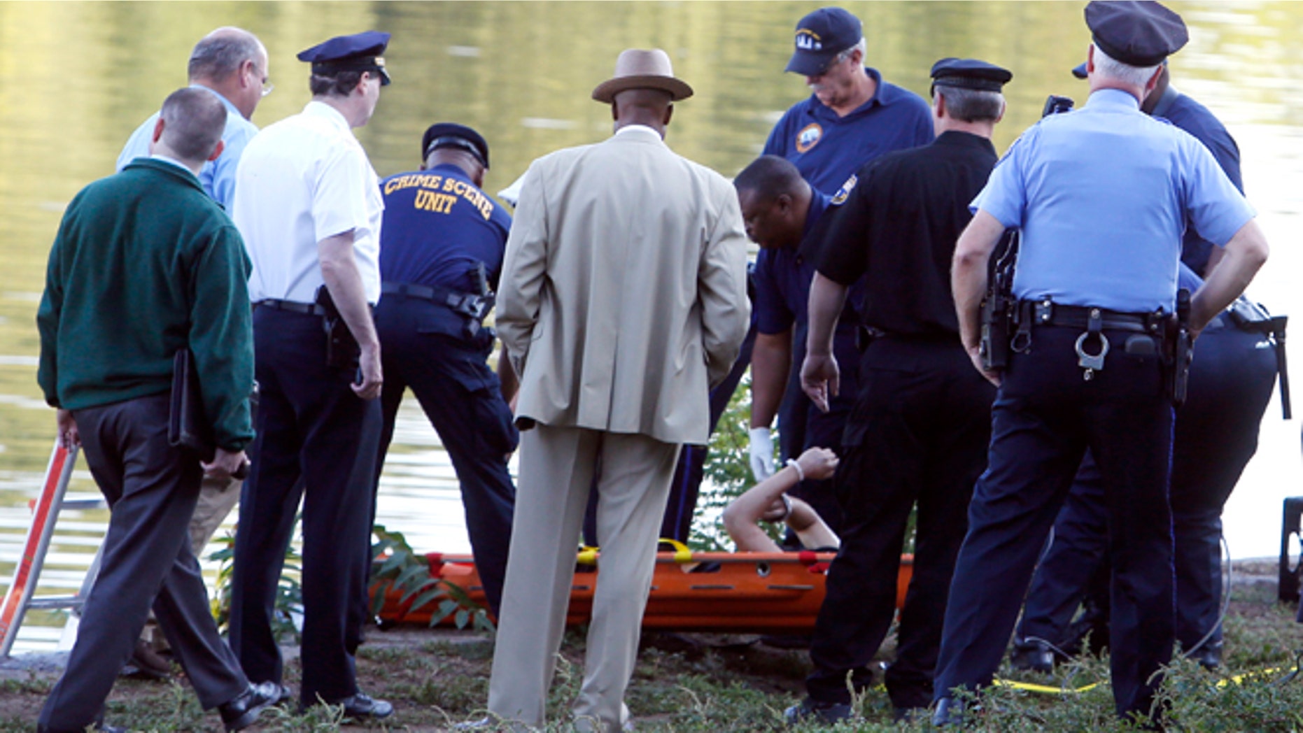 Aug. 27: Philadelphia police and other law enforcement officials view a body pulled from the Schuylkill River in Fairmount Park in Philadelphia. The bound bodies of two people were found in the river Wednesday, and a third man who said he managed to free himself is being treated at a hospital for stab wounds, police said.
