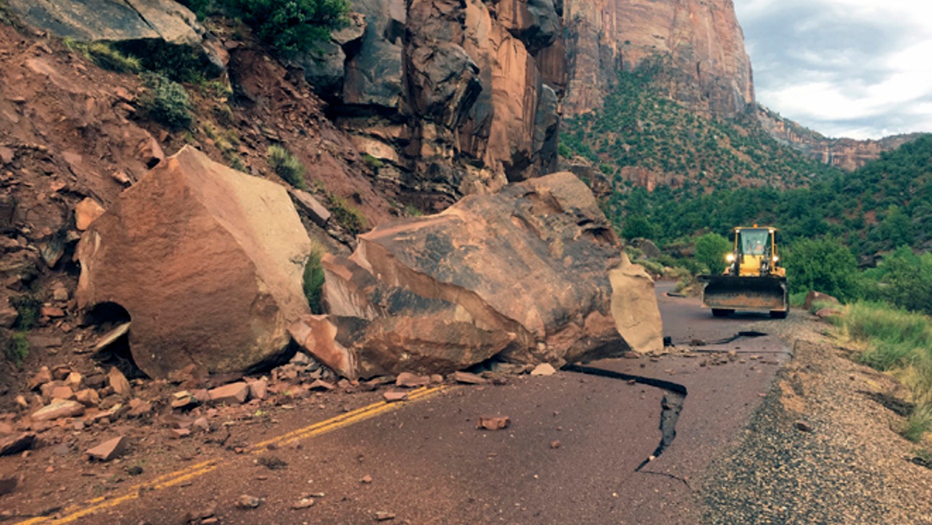 This Wednesday, Aug. 10, 2016 photo provided by the National Park Service shows the Zion- Mount Carmel Highway, State Route 9 closed, in Zion National Park after a boulder tumbled onto the roadway.