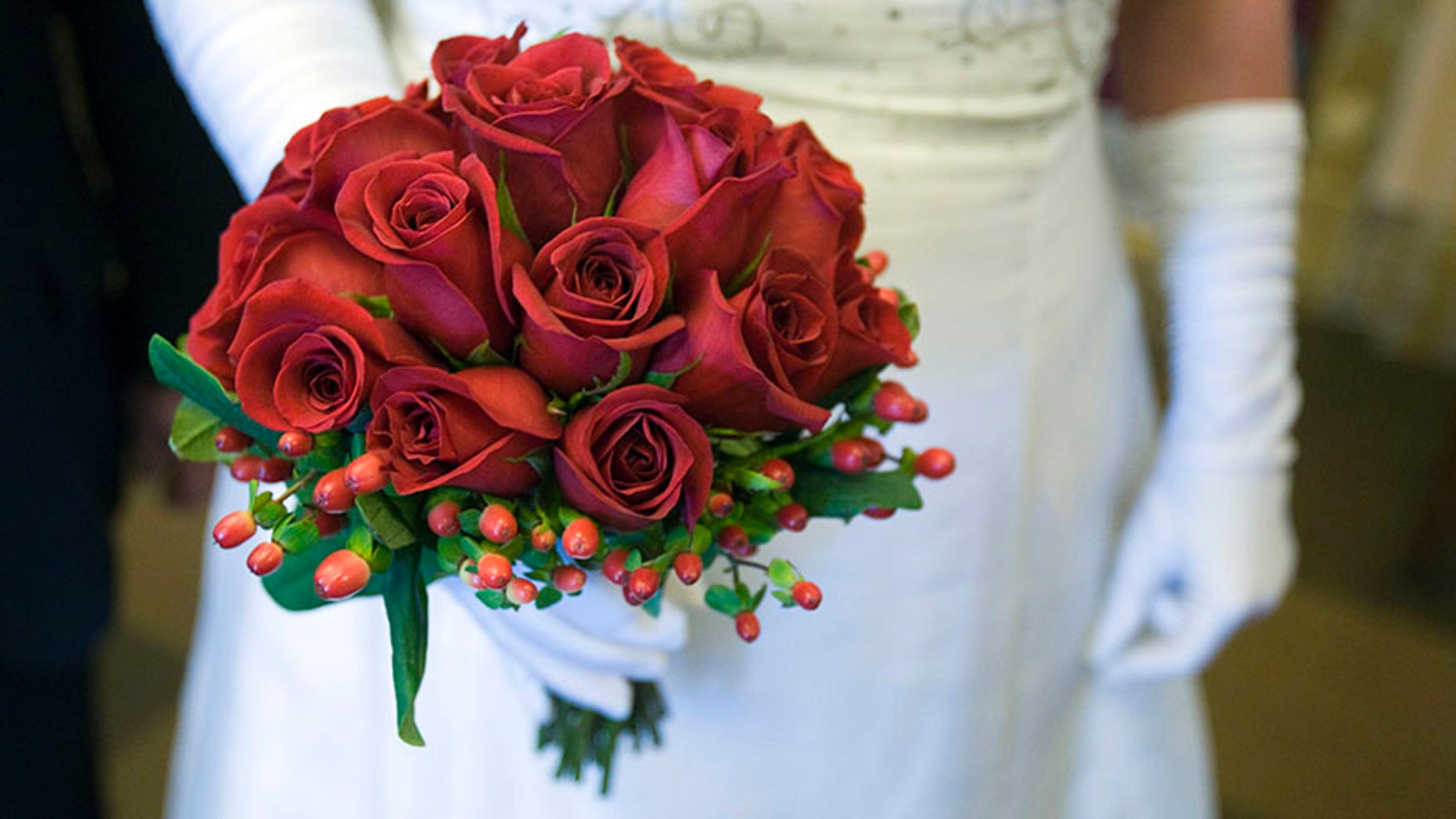 Lorie Lesieur of Pawtucket, Rhode Island, holds a bouquet after being married in The Mob Museum in Las Vegas, Nevada February 14, 2012. Seven couples were chosen at random to get married or renew wedding vows before the museum's grand opening. The museum, in a former federal courthouse and post office, is one of 14 sites in the nation that hosted the 1950-51 U.S. Senate Special Committees to investigate Crime in Interstate Commerce, also known as the Kefauver hearings. REUTERS/Steve Marcus (UNITED STATES - Tags: SOCIETY) - RTR2XV01