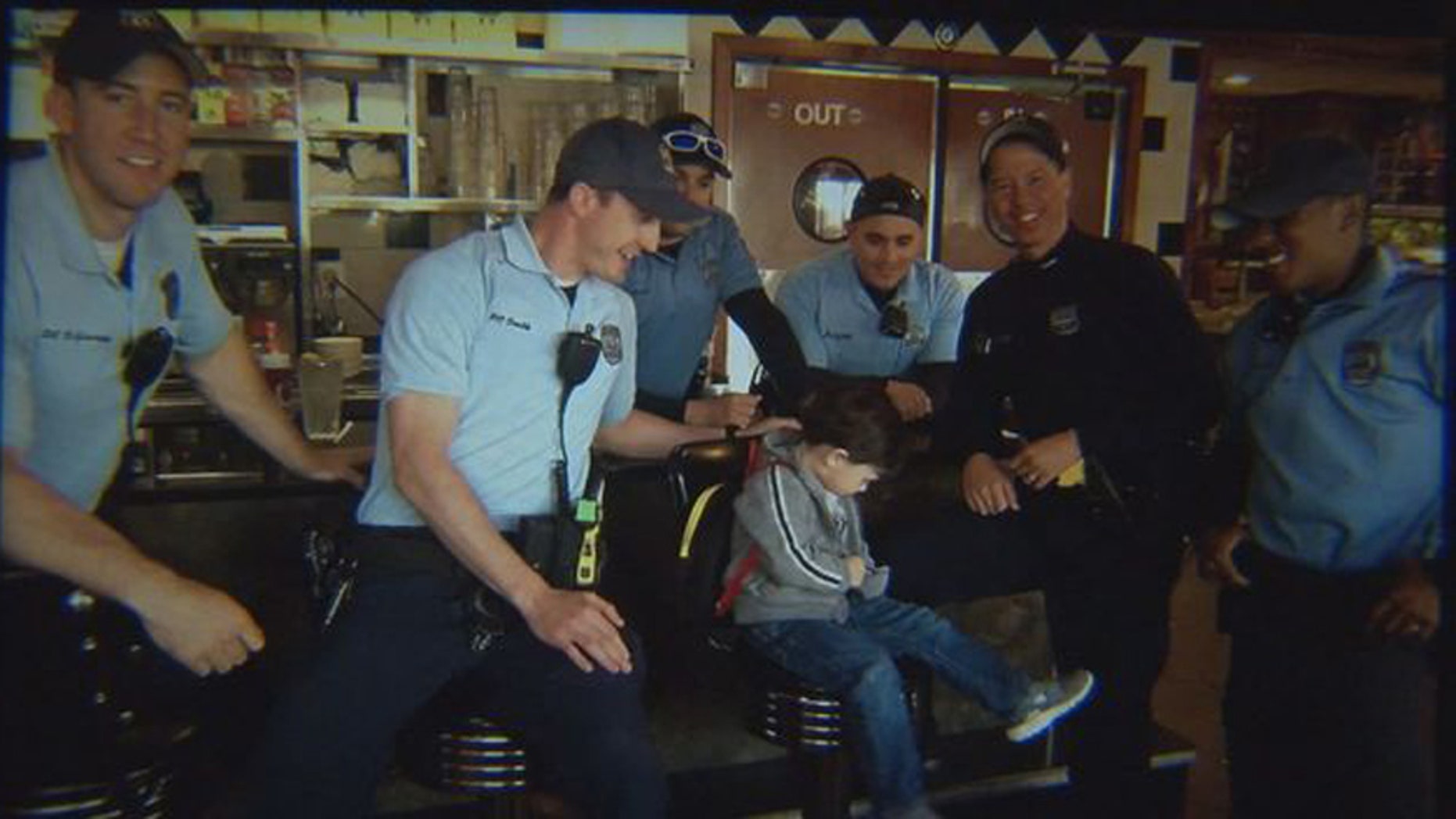 Logan, 3, and a group of police officers for whom he bought coffee.
