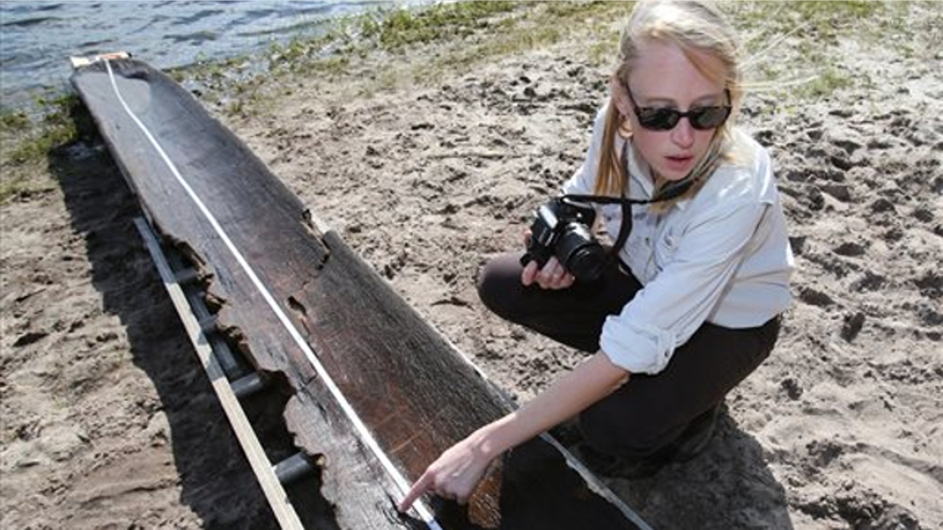 Sept. 19, 2013: Julia Byrd, a senior archaeologist with the Florida Bureau of Archaeological Research points out a burn mark on a dugout canoe found in Owen Lake in the Ocala National Forest east of Ocala, Fla.
