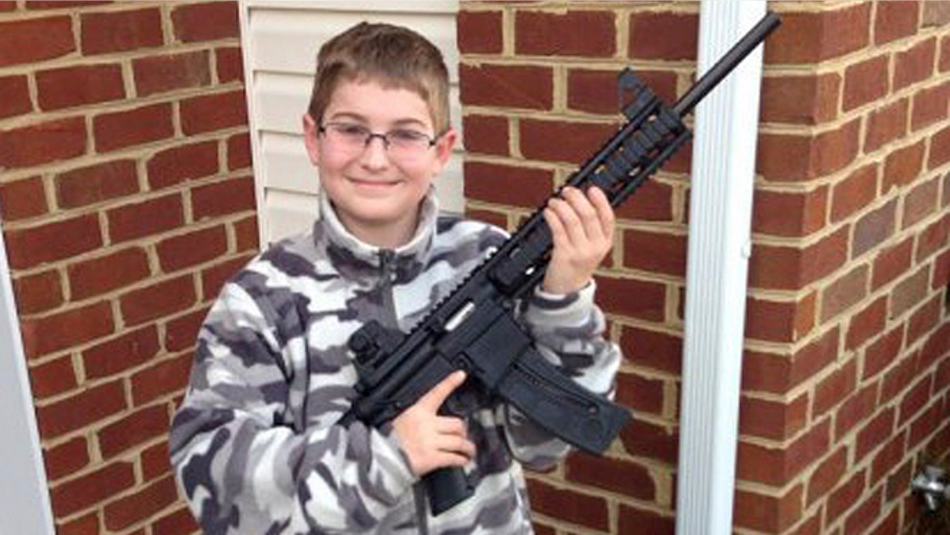 This undated photo provided by Shawn Moore shows his son Josh, 10, holding a rifle his father gave him for his 11th birthday, at their home in Carneys Point, N.J.