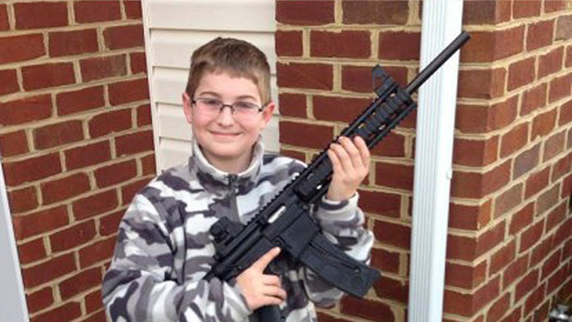 This undated photo provided by Shawn Moore shows his son Josh, 10, holding a rifle his father gave him for his 11th birthday, at their home in Carneys Point, N.J.