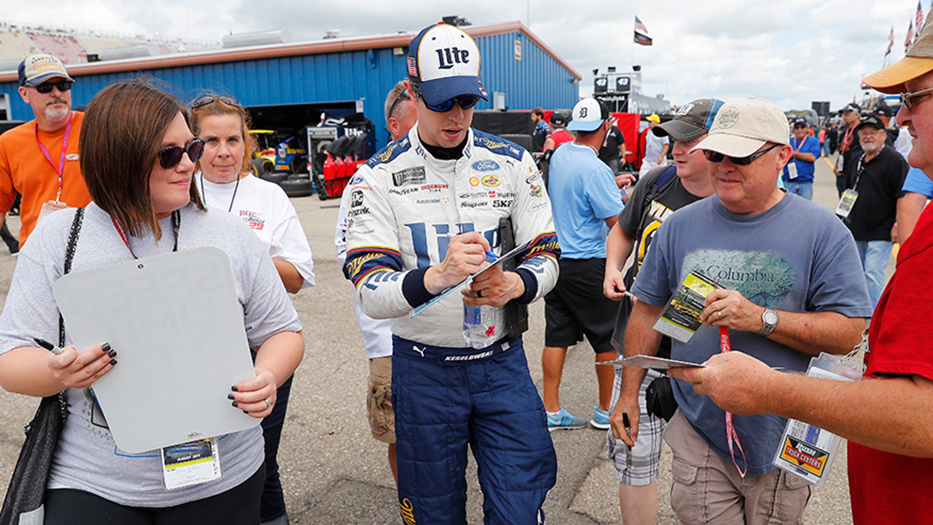 Brad Keselowski signs autographs after practice the NASCAR Cup Series auto race in Brooklyn, Mich., Saturday, Aug. 12, 2017. (AP Photo/Paul Sancya)