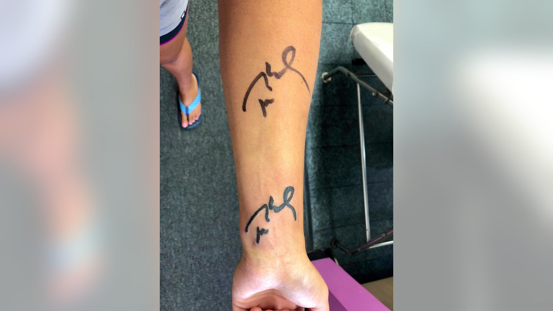 New England Patriots fan Megan Uhrynowski, 19, of Stratford, Conn., displays Patriots quarterback Tom Brady's autograph, top, and a tattoo of Brady's signature, bottom, on her forearm.