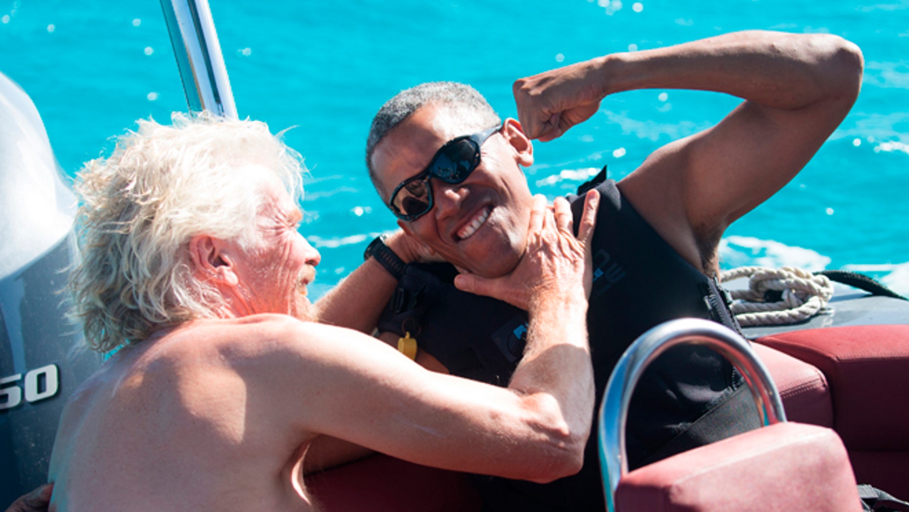 In this recent but undated photo made available by Virgin.com, former U.S President Barack Obama, jokes with Richard Branson, founder of the Virgin Group, during his stay on Moskito Island, British Virgin Islands.