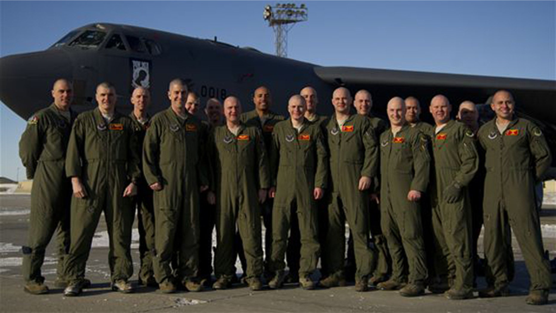 Members of the 23rd Bomb Squadron pose for a group photo with clean-shaven heads for Brayden Mitchell, who was diagnosed with kidney cancer in January.