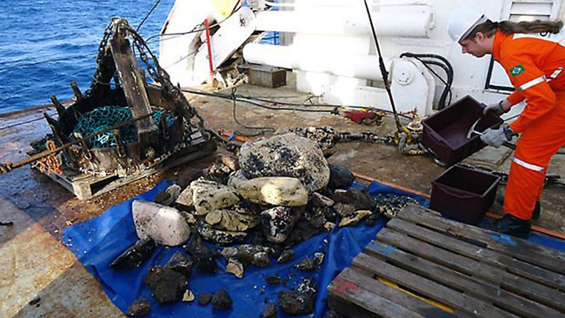 A Geological Service of Brazi member standing next to rocks digged out from the deep-sea during dredging works, 1,500 km from the shore of Rio de Janeiro. According to the CPRM director, Roberto Ventura Santos, the rocks would be part of the former continent submerged when the Atlantic Ocean rose up from the separation of now Africa and South America.