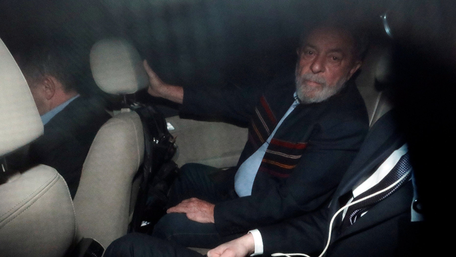 Former Brazilian President Luiz Inacio Lula da Silva, seen inside a car in Sao Paulo on Thursday, faced an arrest warrant.