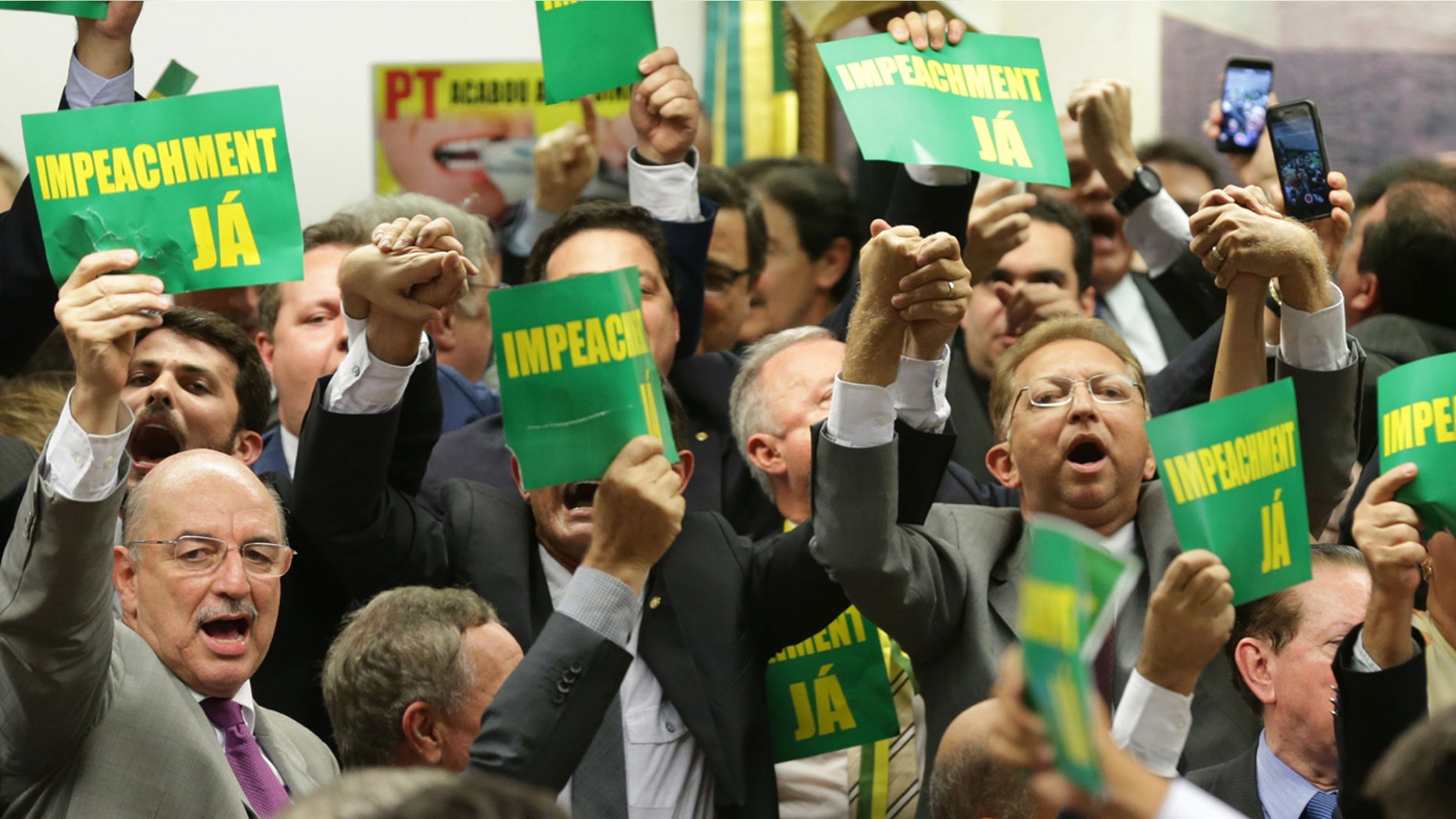 April 11, 2016: As they hold a sign reading "impeachment now" opposition lawmakers celebrate after the results of the voting at a congressional committee in Brasilia, Brazil