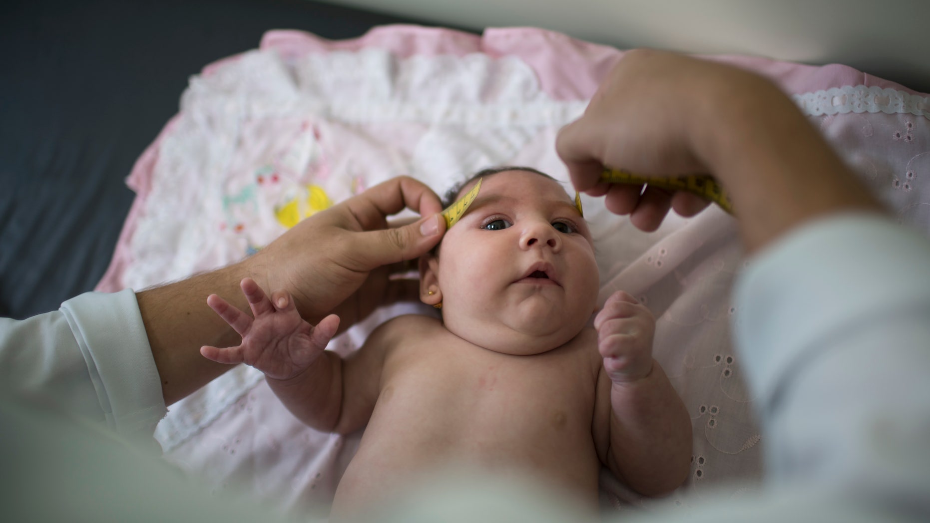 In this Dec. 22, 2015 photo, Luiza has her head measured by a neurologist at the Mestre Vitalino Hospital in Caruaru, Pernambuco state, Brazil. Luiza was born in October with a head that was just 11.4 inches (29 centimeters) in diameter, more than an inch (3 centimeters) below the range defined as healthy by doctors. Her rare condition, known as microcephaly, often results in mental retardation. (AP Photo/Felipe Dana)