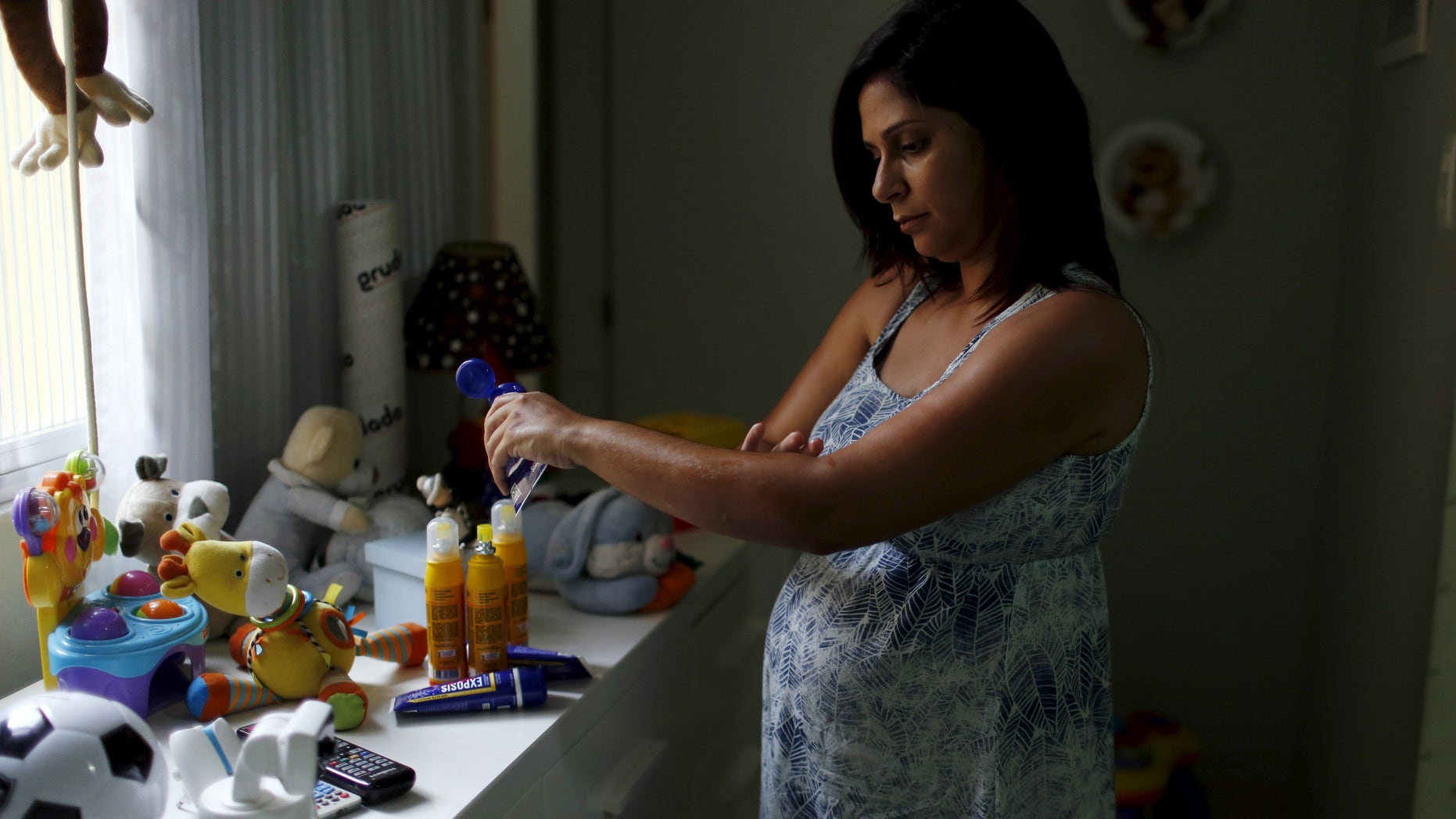 Gisele Felix, who is five months pregnant, applies repellent on her arm at her home in Rio de Janeiro, Brazil, January 28, 2016. Fear of the mosquito-borne Zika virus has Brazilians rushing to buy repellant, creating a shortage of some brands on pharmacy shelves and boosting sales for the industry - a trend some producers are preparing for elsewhere as the outbreak spreads. Picture taken January 28, 2016. REUTERS/Pilar Olivares - RTX25L1M