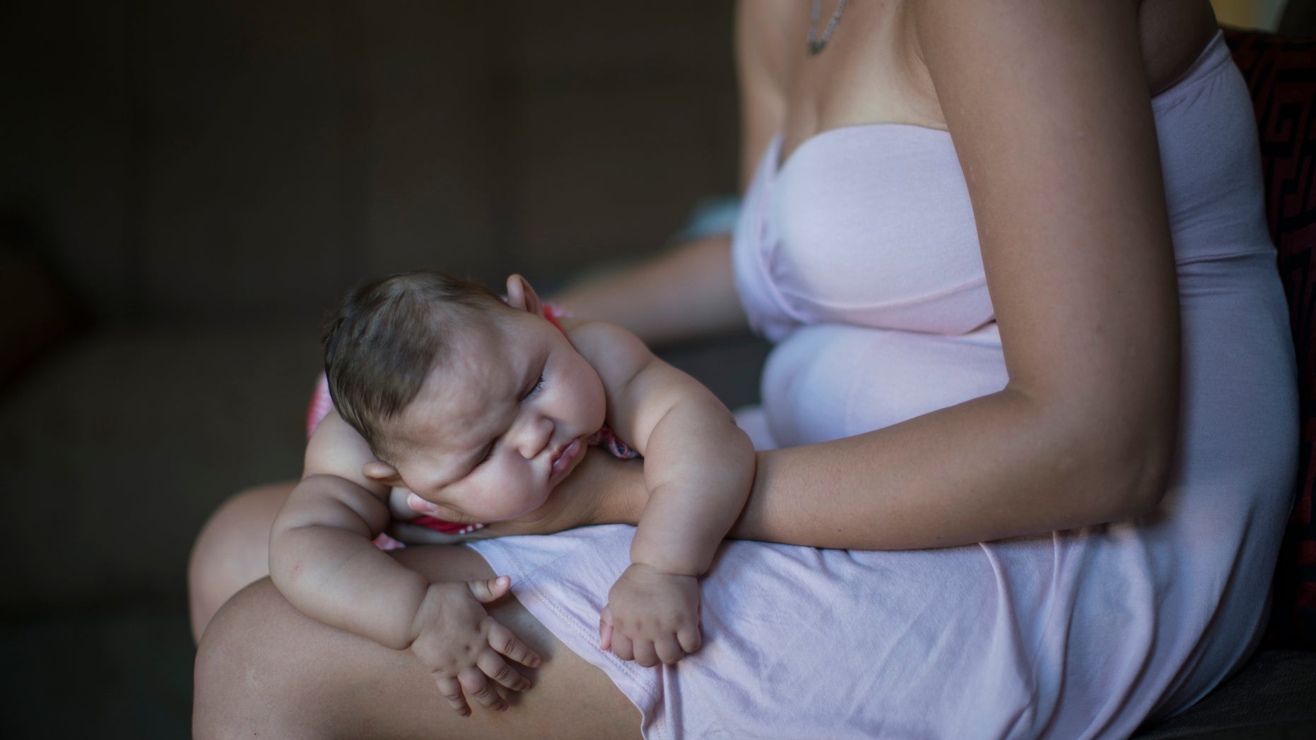 Gleyse Kelly da Silva holds her daughter Maria Giovanna as she sleeps in their house in Recife, Pernambuco state, Brazil, Wednesday, Jan. 27, 2016. Brazilian officials still say they believe there's a sharp increase in cases of microcephaly and strongly suspect the Zika virus, which first appeared in the country last year, is to blame. The concern is strong enough that the U.S. Centers for Disease Control and Prevention this month warned pregnant women to reconsider visits to areas where Zika is present. (AP Photo/Felipe Dana)