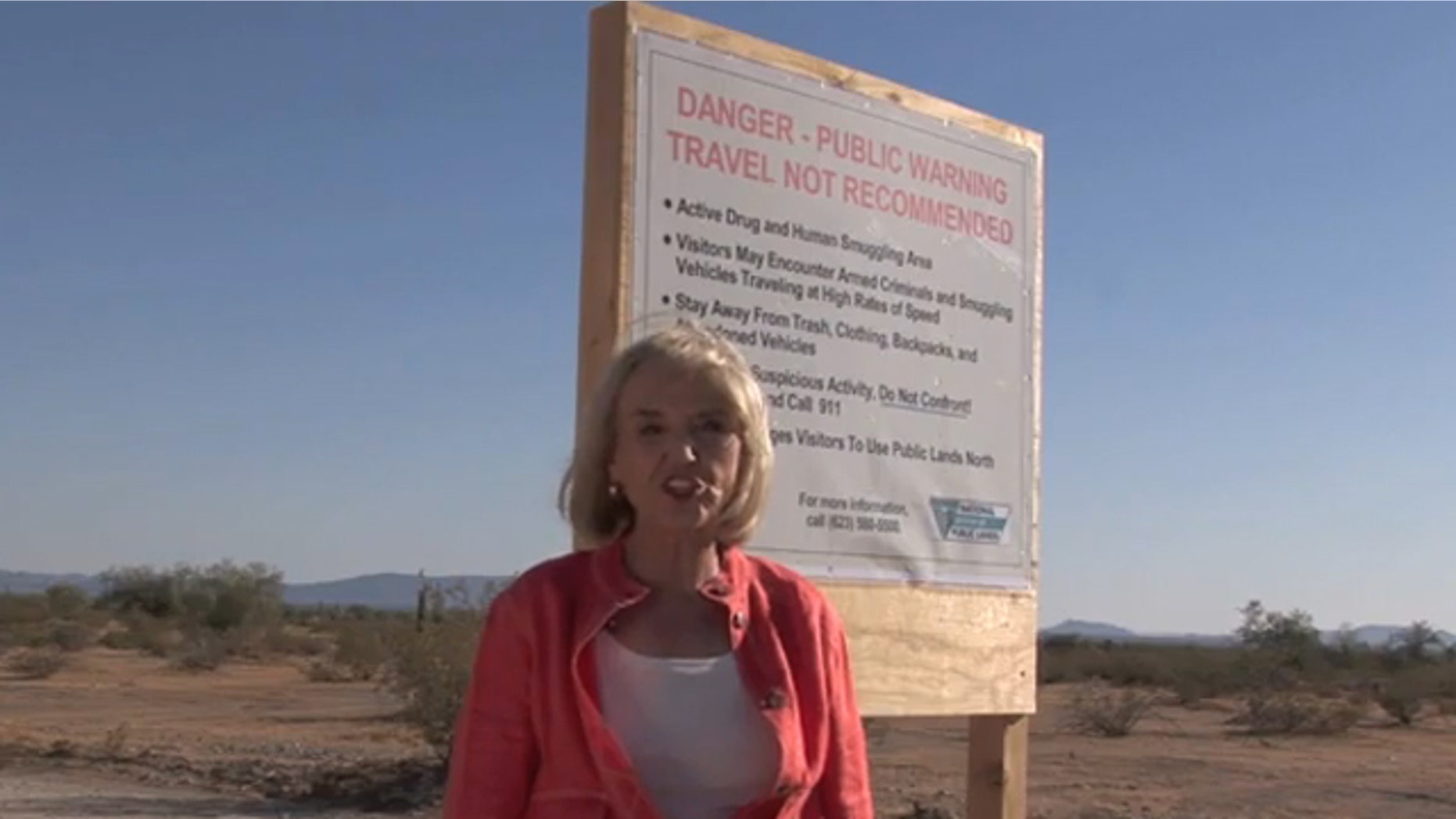 Arizona Gov. Jan Brewer is shown next to a warning sign in the desert in a campaign ad. (Governor Jan Brewer 2010)