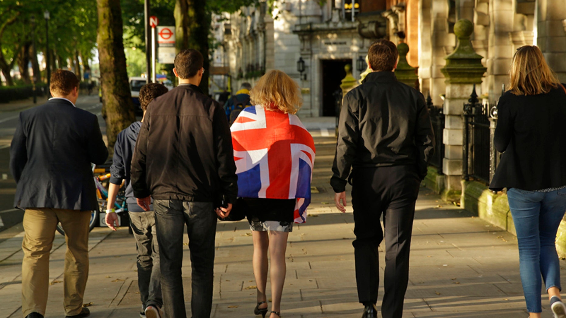 Vote Leave supporters walk along a street in central London, Friday, June 24, 2016. Britain entered uncharted waters Friday after the country voted to leave the European Union, according to a projection by all main U.K. broadcasters. (AP Photo/Matt Dunham)