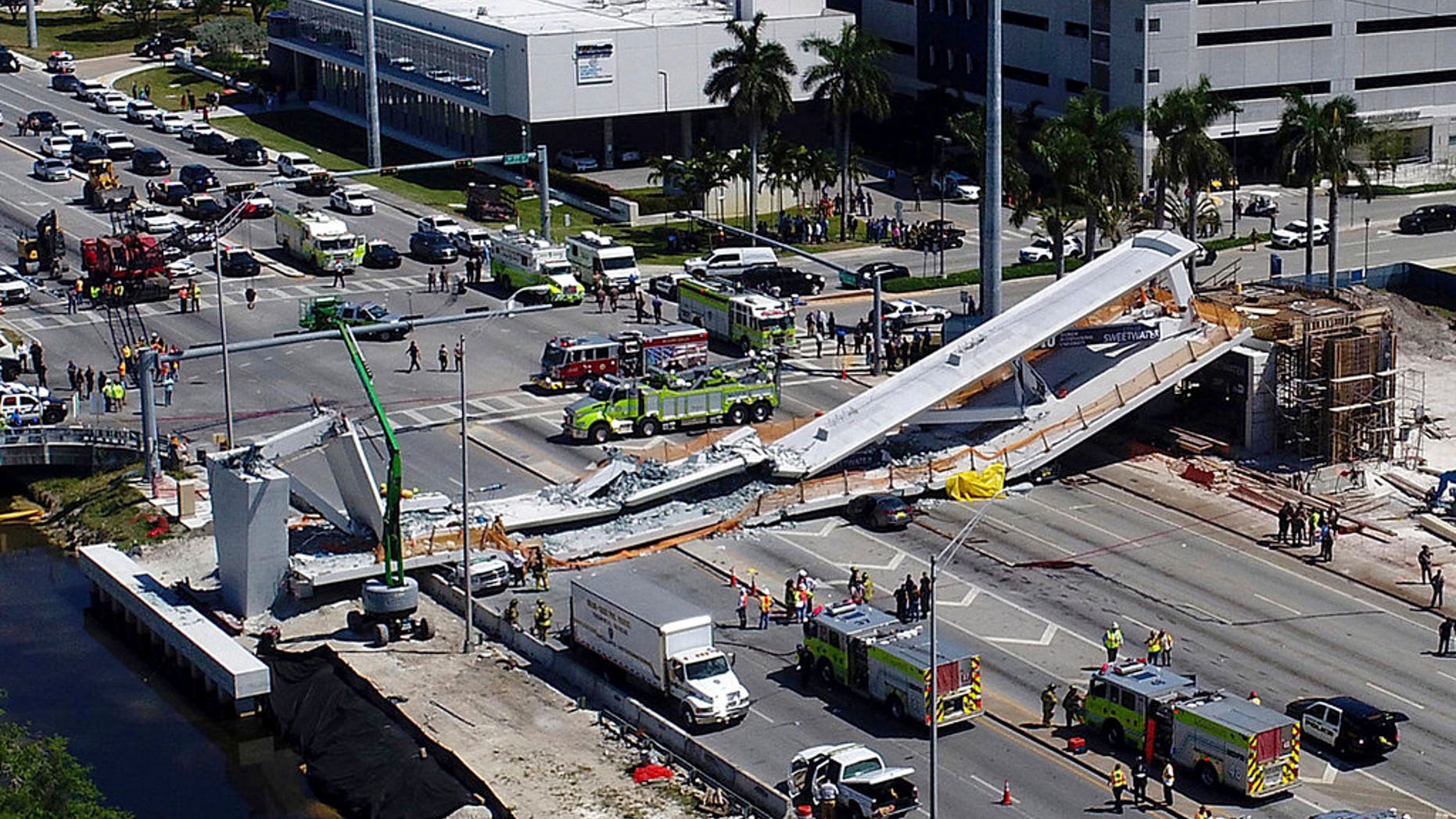 Emergency personnel respond after a brand-new pedestrian bridge collapsed onto a highway at Florida International University in Miami on Thursday, March 15, 2018. The pedestrian bridge collapsed onto the highway crushing multiple vehicles and killing several people. (Pedro Portal/Miami Herald via AP)