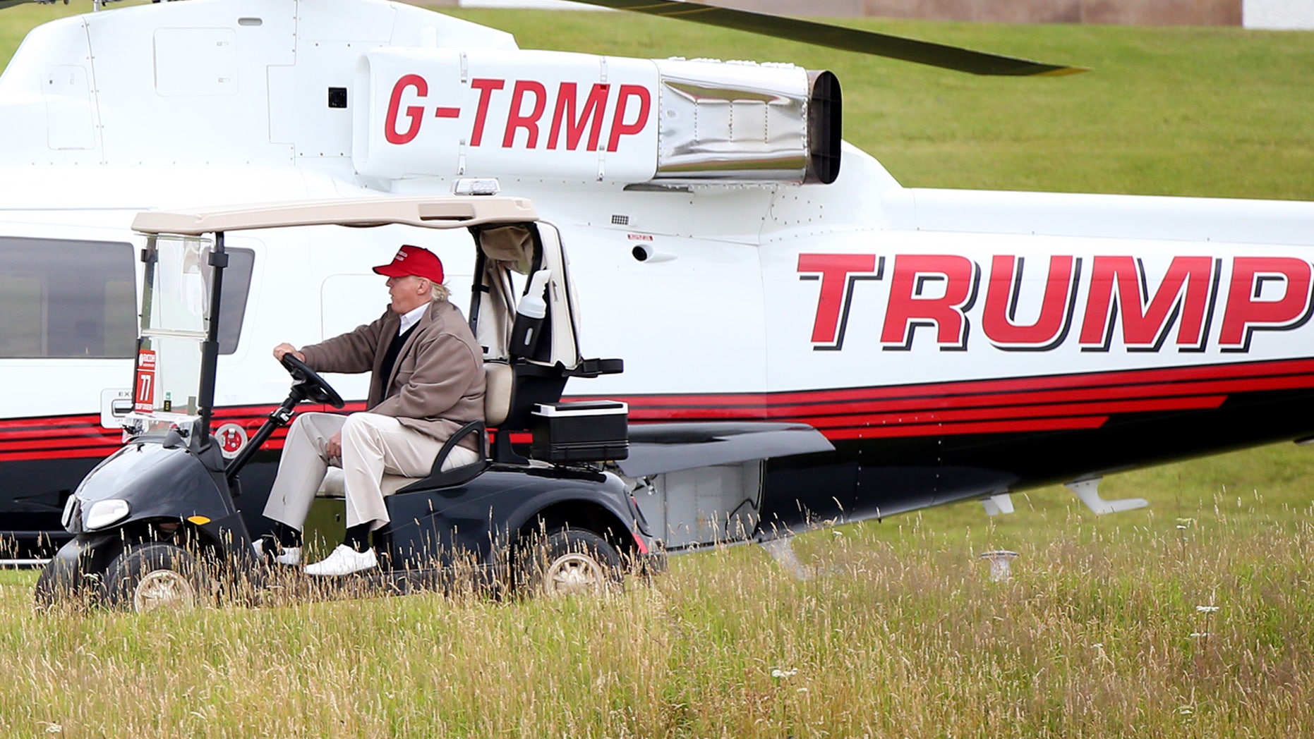 July 31, 2015: US presidential contender Donald Trump drives his golf buggy past his helicopter during the second day of the Women's British Open golf championship on his Turnberry golf course in Turnberry, Scotland.