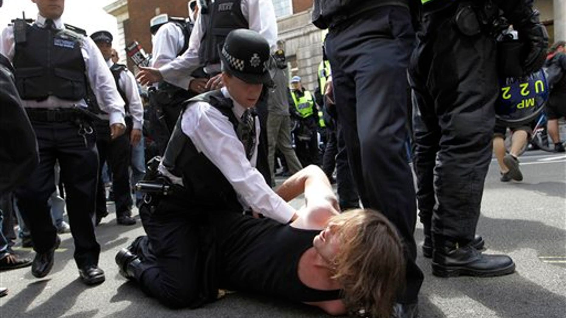 June 30: A British police officer holds down a protester in Whitehall, London as thousands of public sector workers and teachers protest in central London in a one day strike over pension and government cuts. British teachers and public service workers swapped classrooms and offices for picket lines as hundreds of thousands walked off the job to protest pension cuts.
