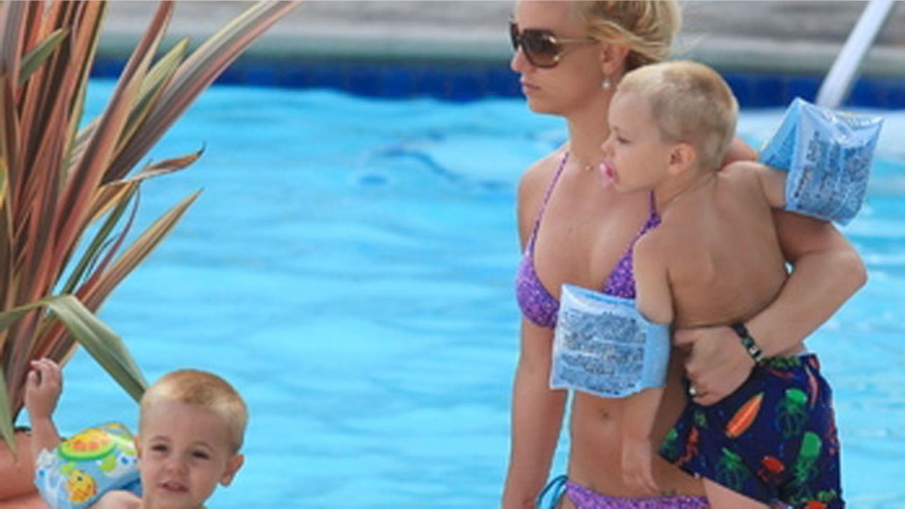 2009: Britney hangs poolside with her two young sons.