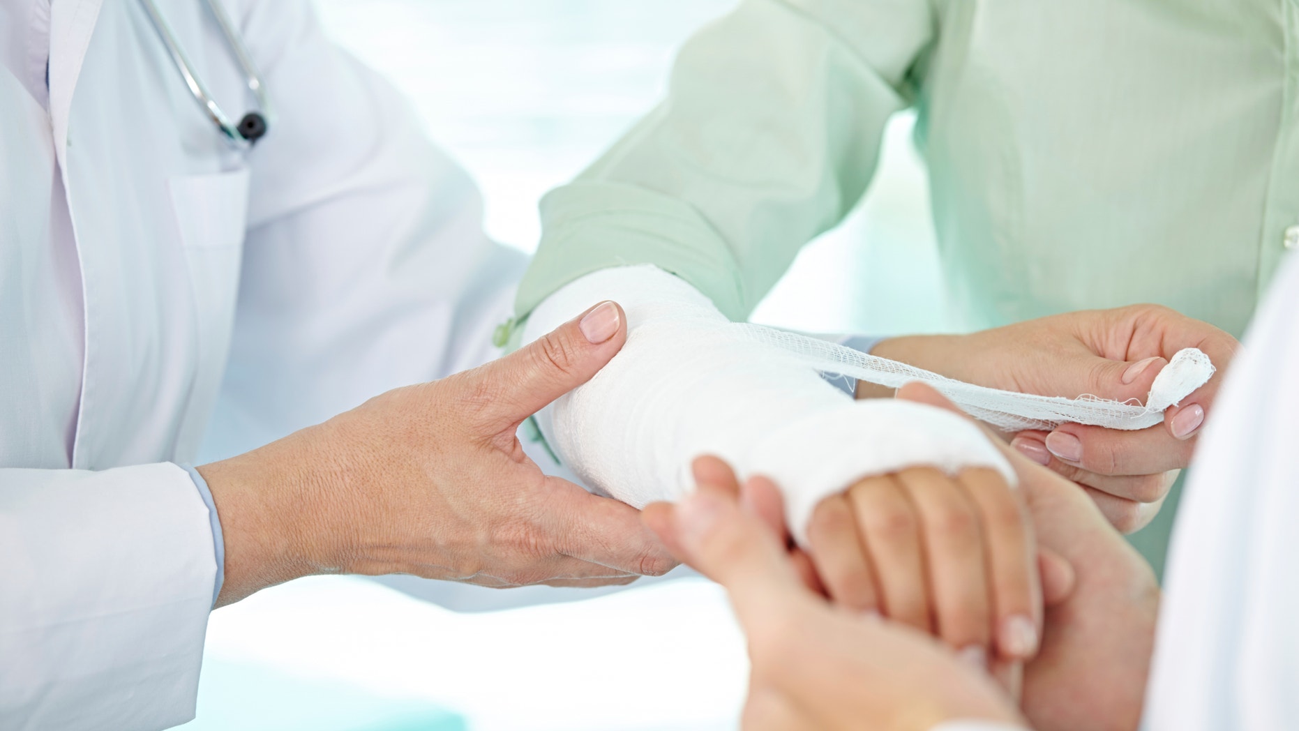Doctor and nurse bandaging patients broken arm