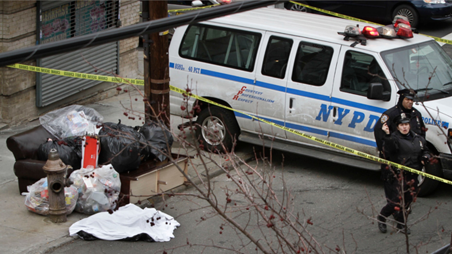 Feb. 26, 2013: Police guard a sheet-covered plastic bag, left, on Eagle Avenue in the Bronx borough of New York.