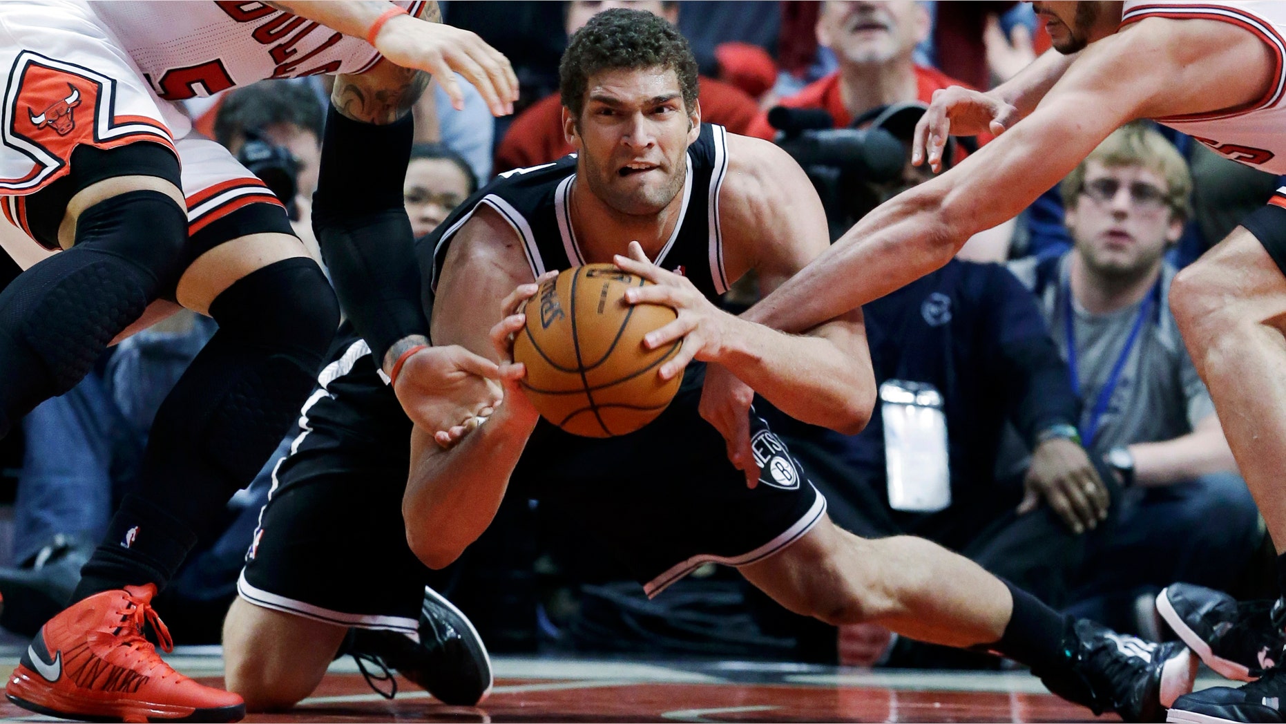 Brooklyn Nets center Brook Lopez, center, looks to a pass against Chicago Bulls forward Carlos Boozer, left, and center Joakim Noah during the second half in Game 6 of their first-round NBA basketball playoff series in Chicago, Thursday, May 2, 2013. The Nets won 95-92. (AP Photo/Nam Y. Huh)